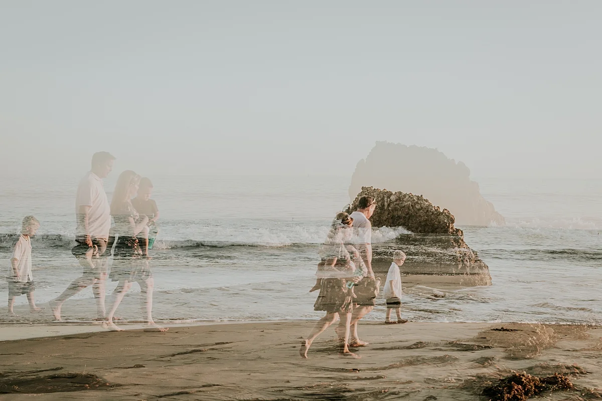 orange county family photographer double exposure photo of family of four walking at corona del mar state beach california