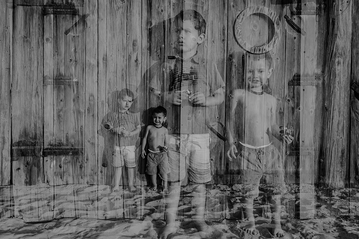 Orange County family photographer. double exposure photo of young brothers playing with car toys in the sand at Huntington Beach Pier during outdoor family photo session with Krystil McDowall Photography
