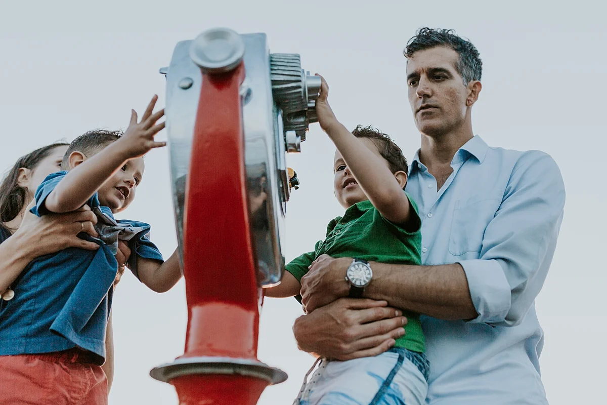 Orange County family photographer. Photo of family of four playing on the pier at Huntington Beach during family photo shoot with Krystil McDowall Photography