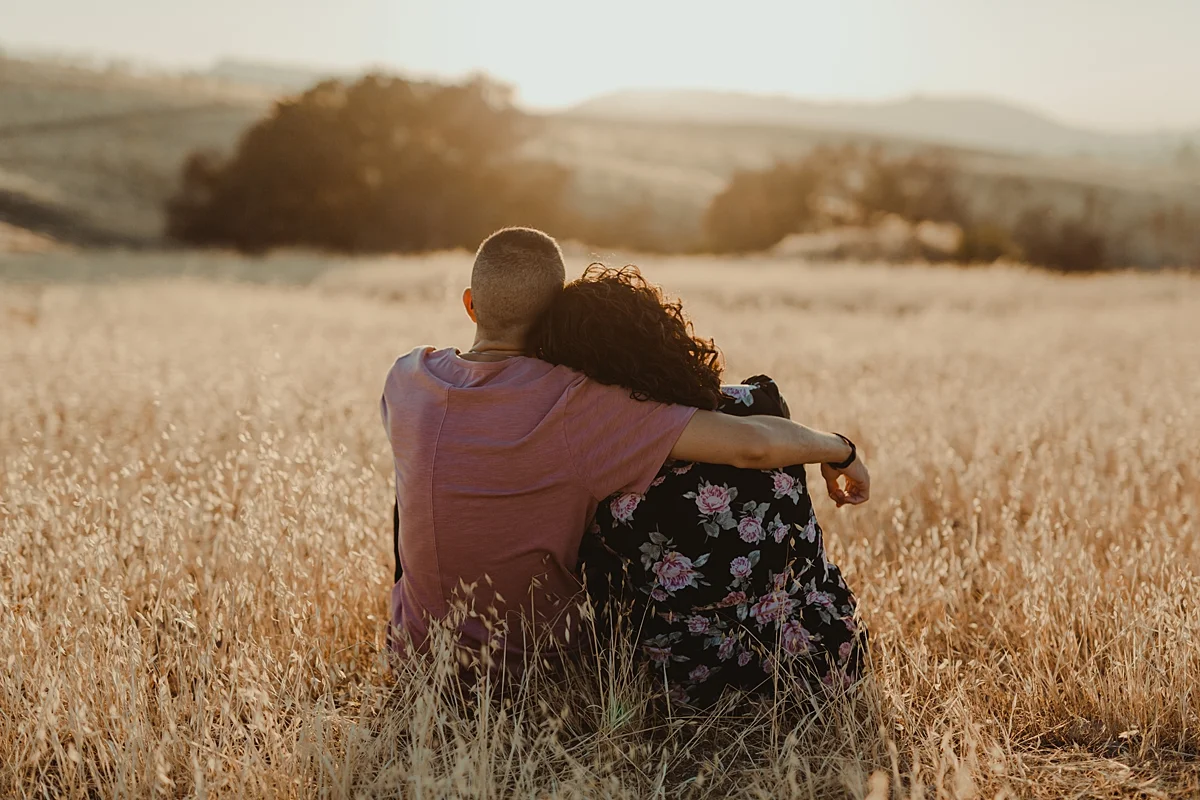 orange county family photographer. image of couple sitting relaxed amongst the fields at Irvine Regional Park Orange County as the sunsets