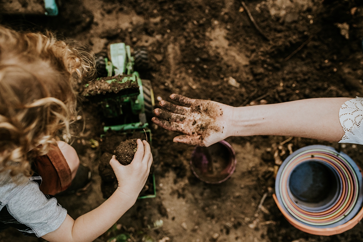 Orange County family photographer. Photo of mother and son making dirt balls in their front garden during documentary photo session with Krystil McDowall Photography