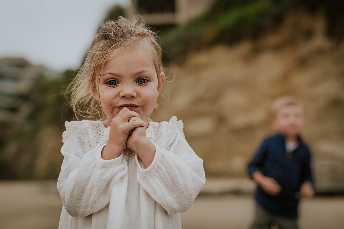 Orange County family photographer. Portrait of sweet two year old girl standing looking at the waves at Table Rock Beach, Laguna Beach