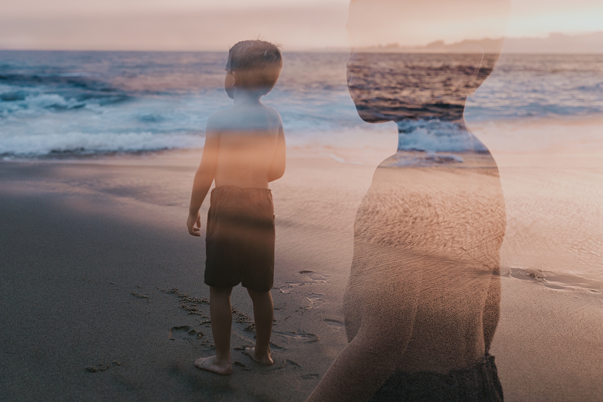 Orange County family photographer. Double exposure photo of young boy standing in the shallow waves at Table Rock Beach Laguna Beach during photo session with Krystil McDowall Photography