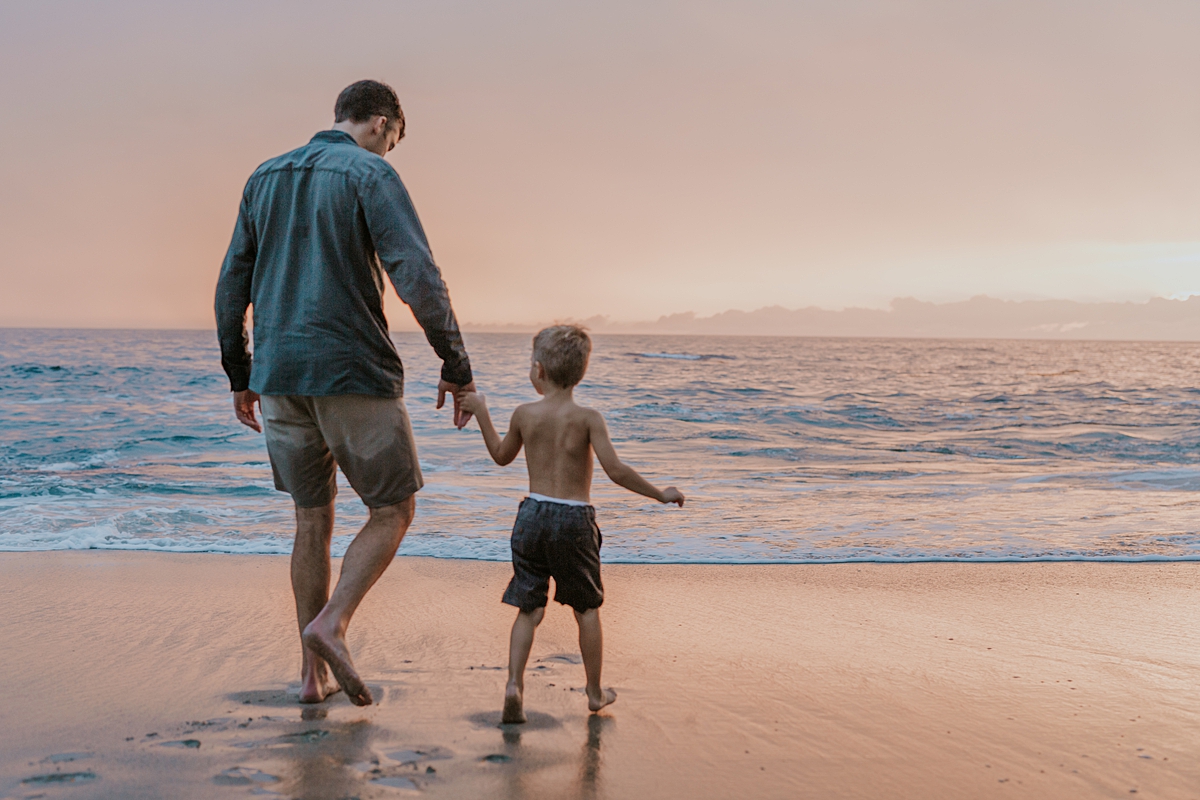 Orange County family photographer. Photo of walking out into ocean hand-in-hand at sunset at Table Rock Beach Laguna Beach during photo session with Krystil McDowall Photography