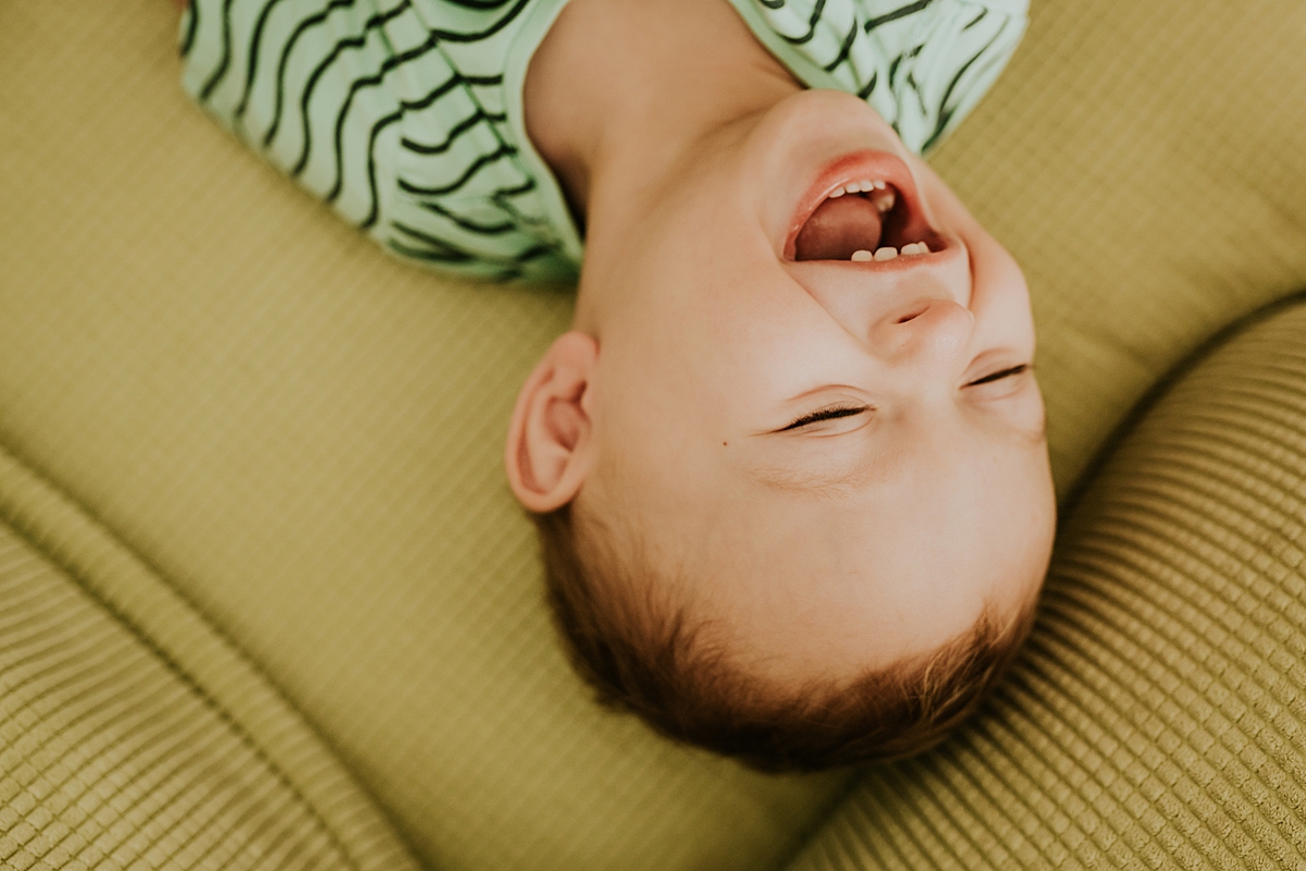 Orange County family photographer. photo of toddler laughing his sweet little head off during in-home newborn session with Krystil McDowall Photography