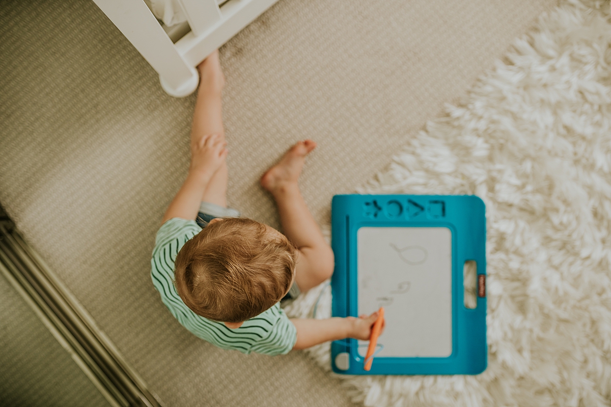 Orange County family photographer. Portrait of older son playing with doodle pro in his room