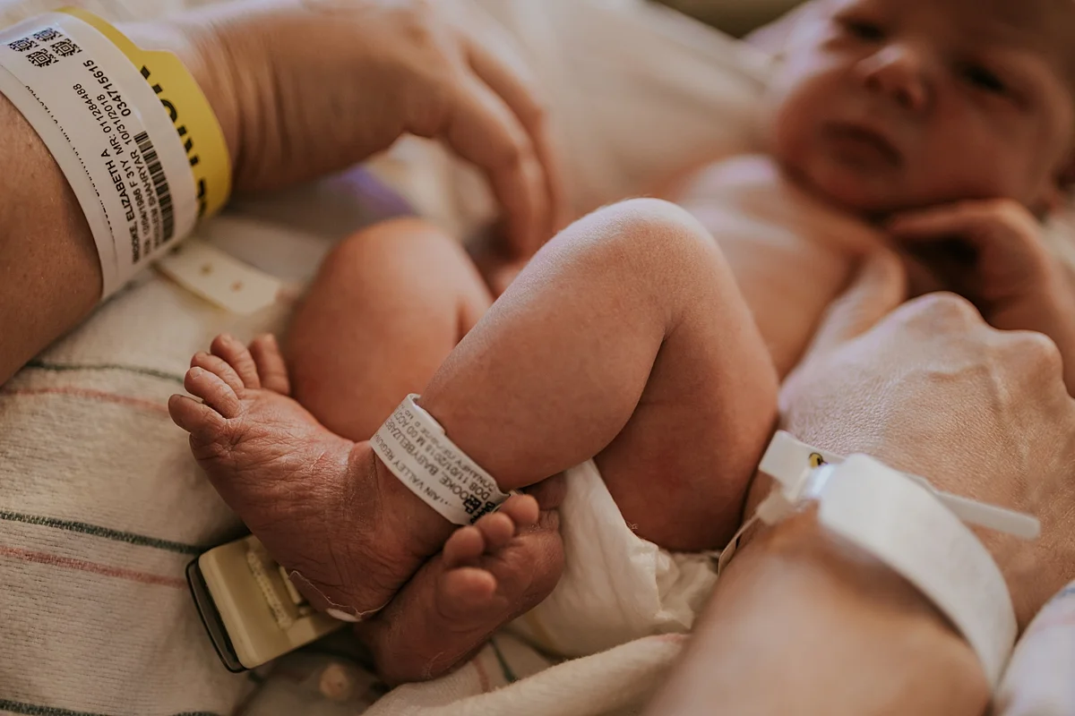 Orange County family photographer. Photo of two day old newborn baby laying on hospital blankets during fresh 48 session with Krystil McDowall Photography