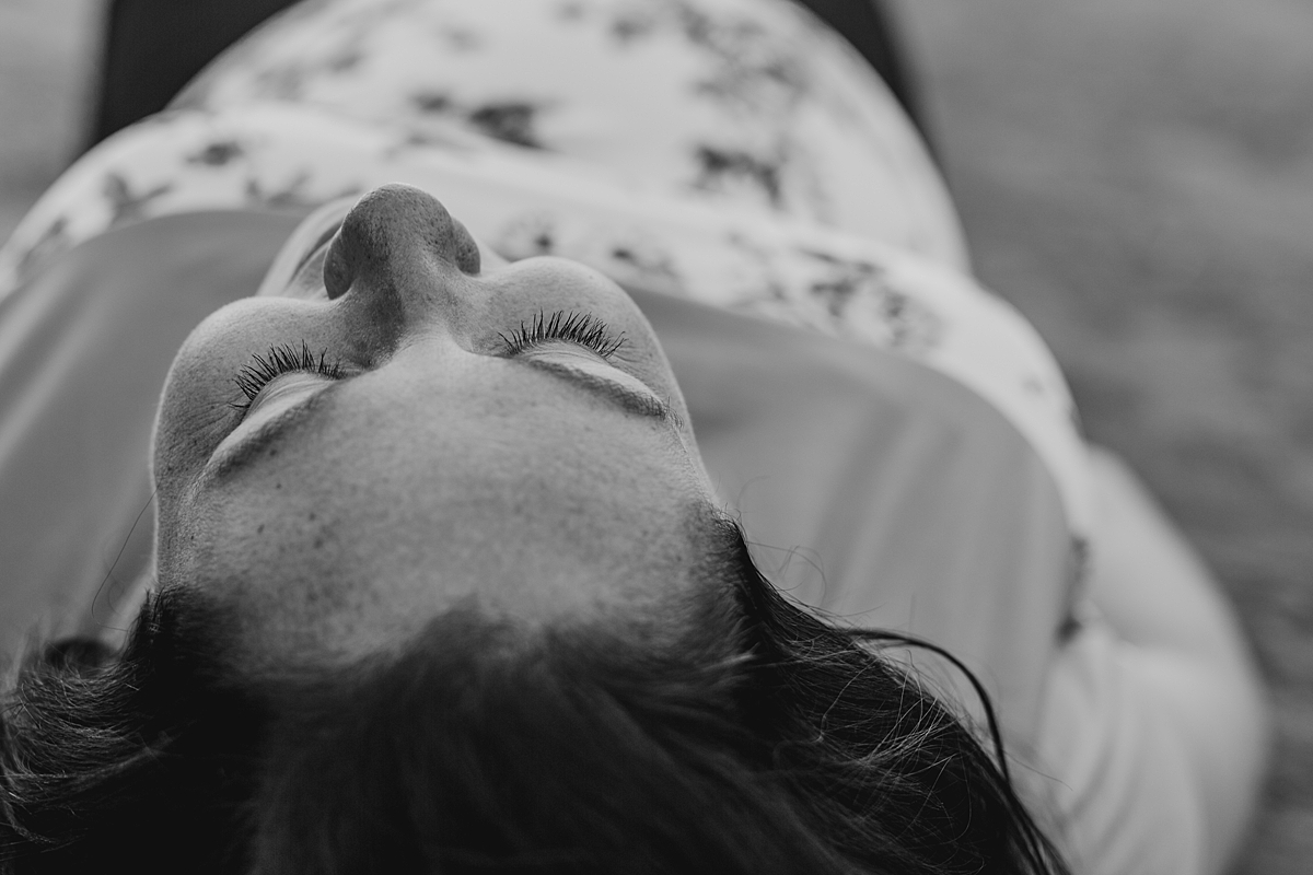 Orange County family photographer. Photo of pregnant mom laying across her husband's lap during outdoor maternity photo session at Irvine Regional Park