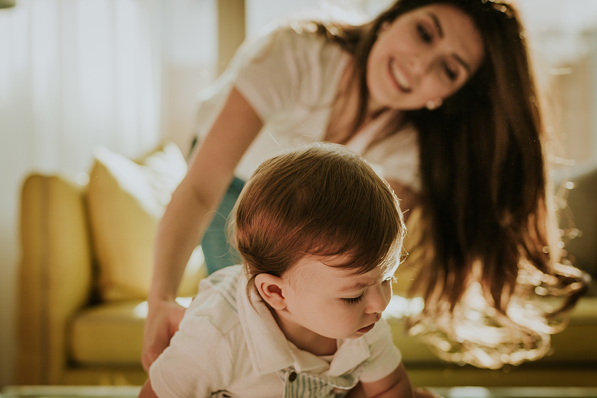 Orange County family photographer. Candid photo of mom and her one year old son taken during family photo session in Irvine CA