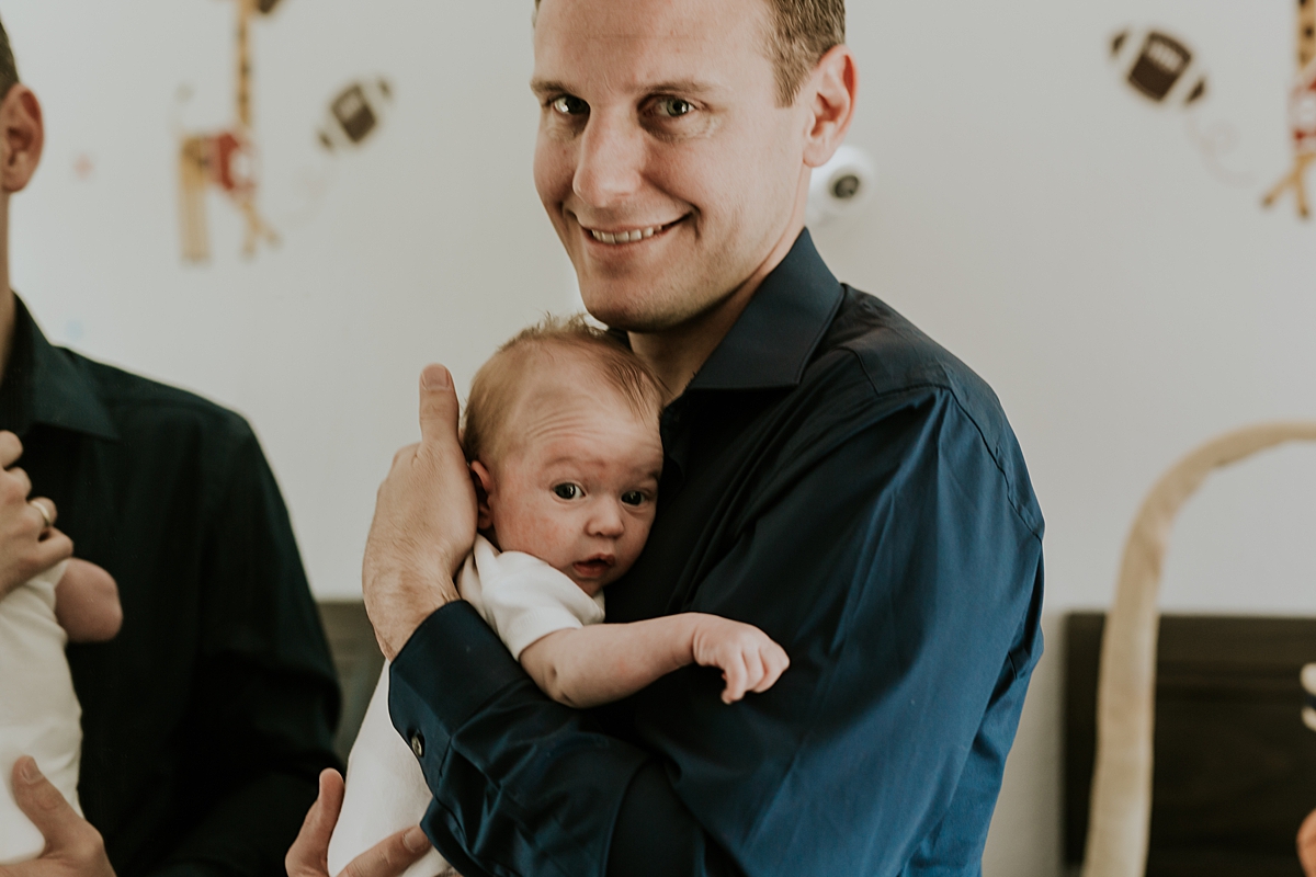 Orange County family photographer. Photo of dad holding his newborn son during newborn photo shoot in Mission Viejo Orange County