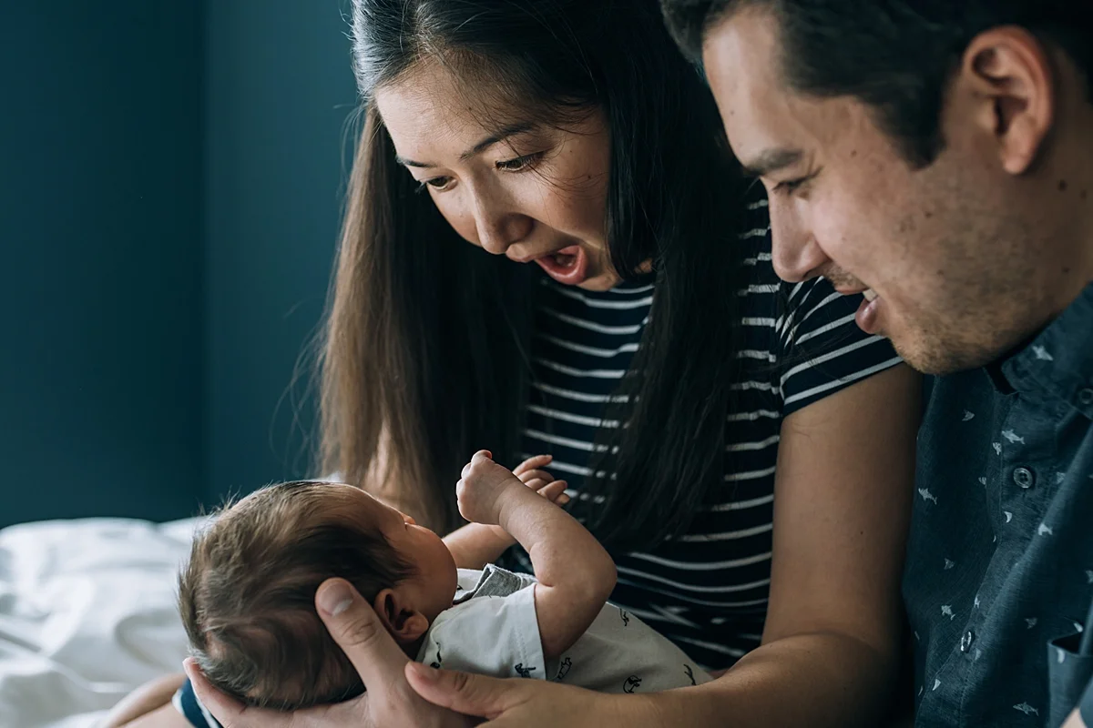 Orange County family photographer. Candid photo of mom playing with her newborn son during in home newborn photo shoot in Lake Forest Orange County