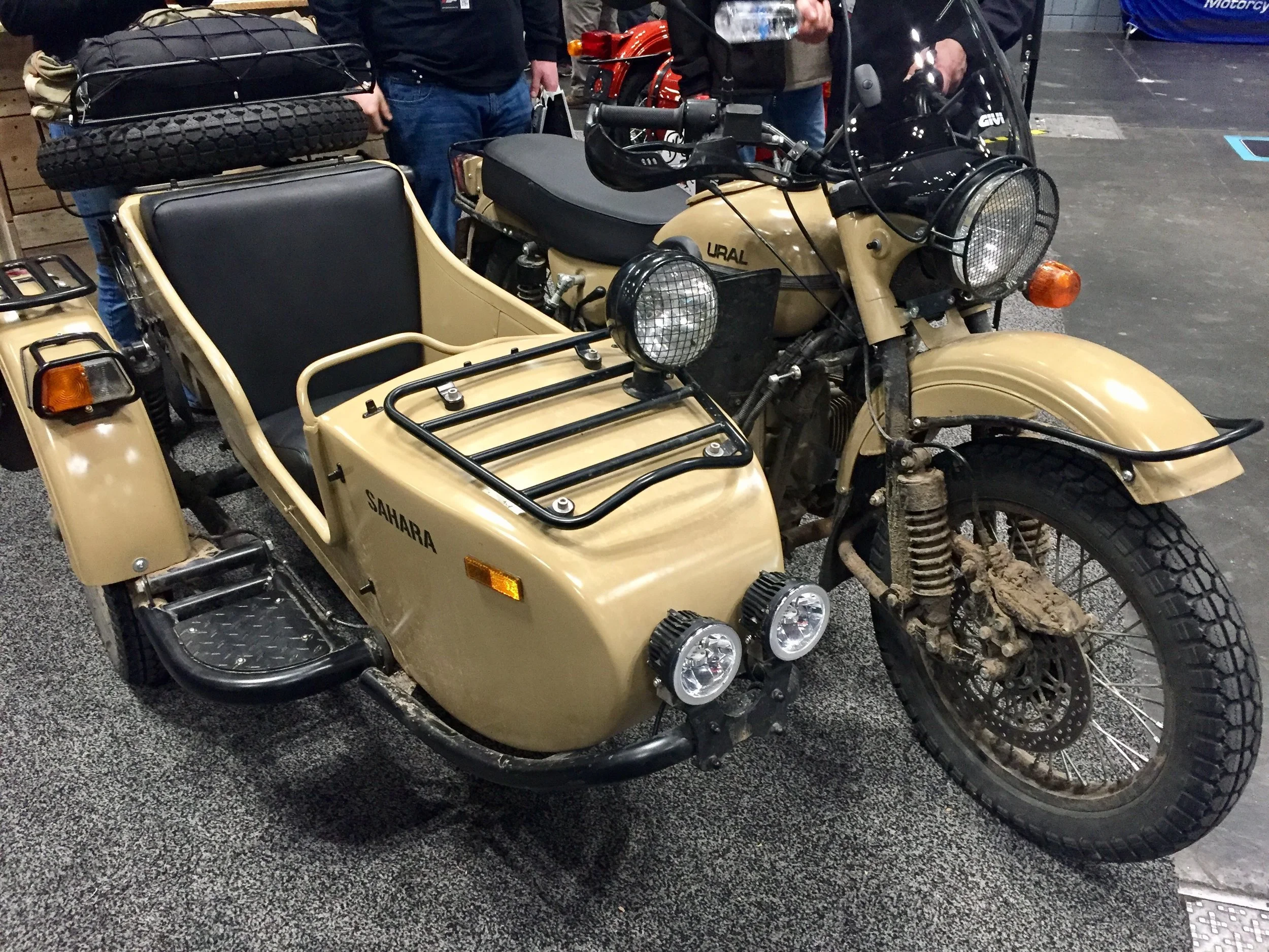Caked-on mud on the front forks shows the rugged agility of this Ural Sahara and sidecar.