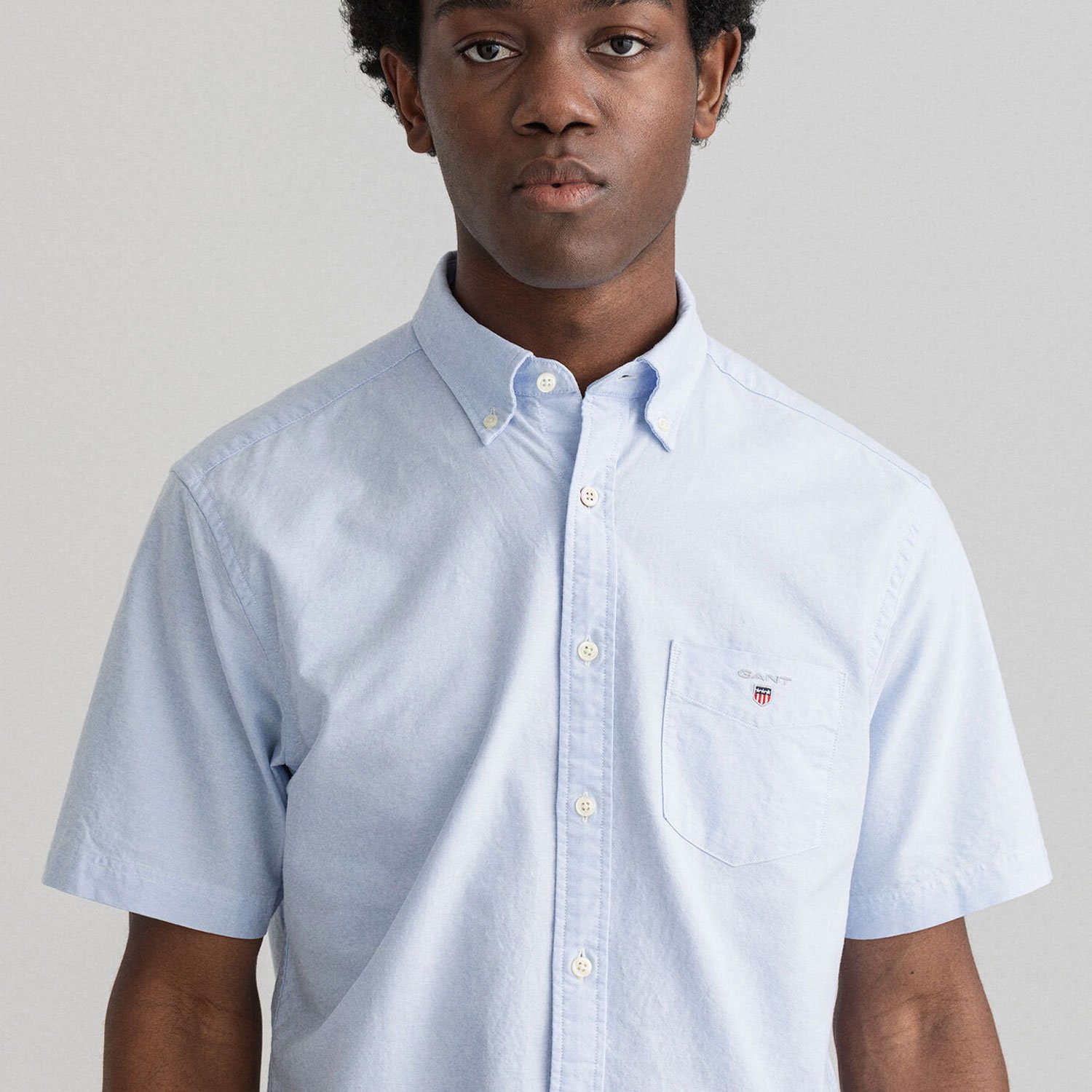 Close-up of model wearing GANT Regular-Fit Short-Sleeve Oxford Shirt in Light Blue