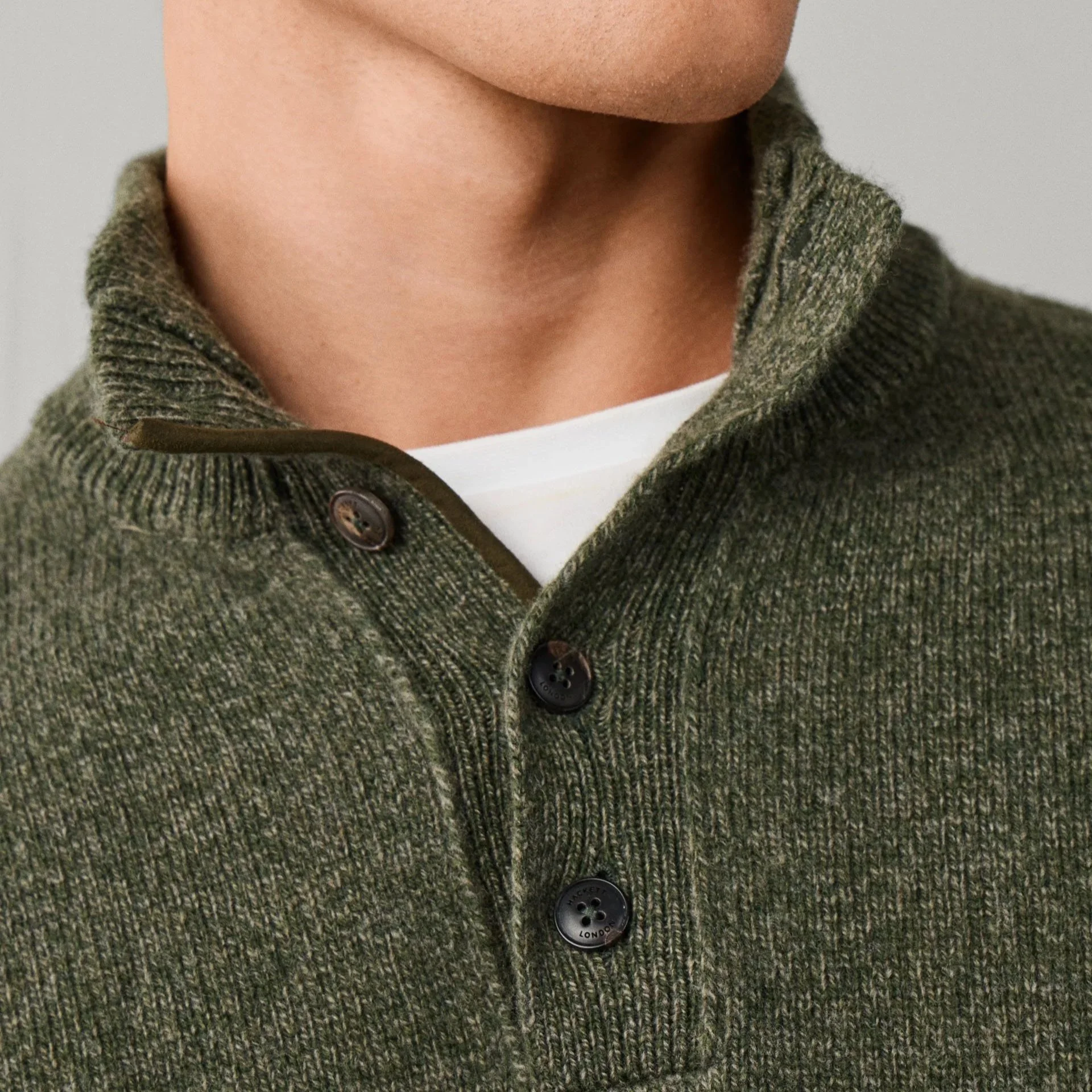 Close View of Model in Hackett Merino Wool Half Button Jumper in Olive Green