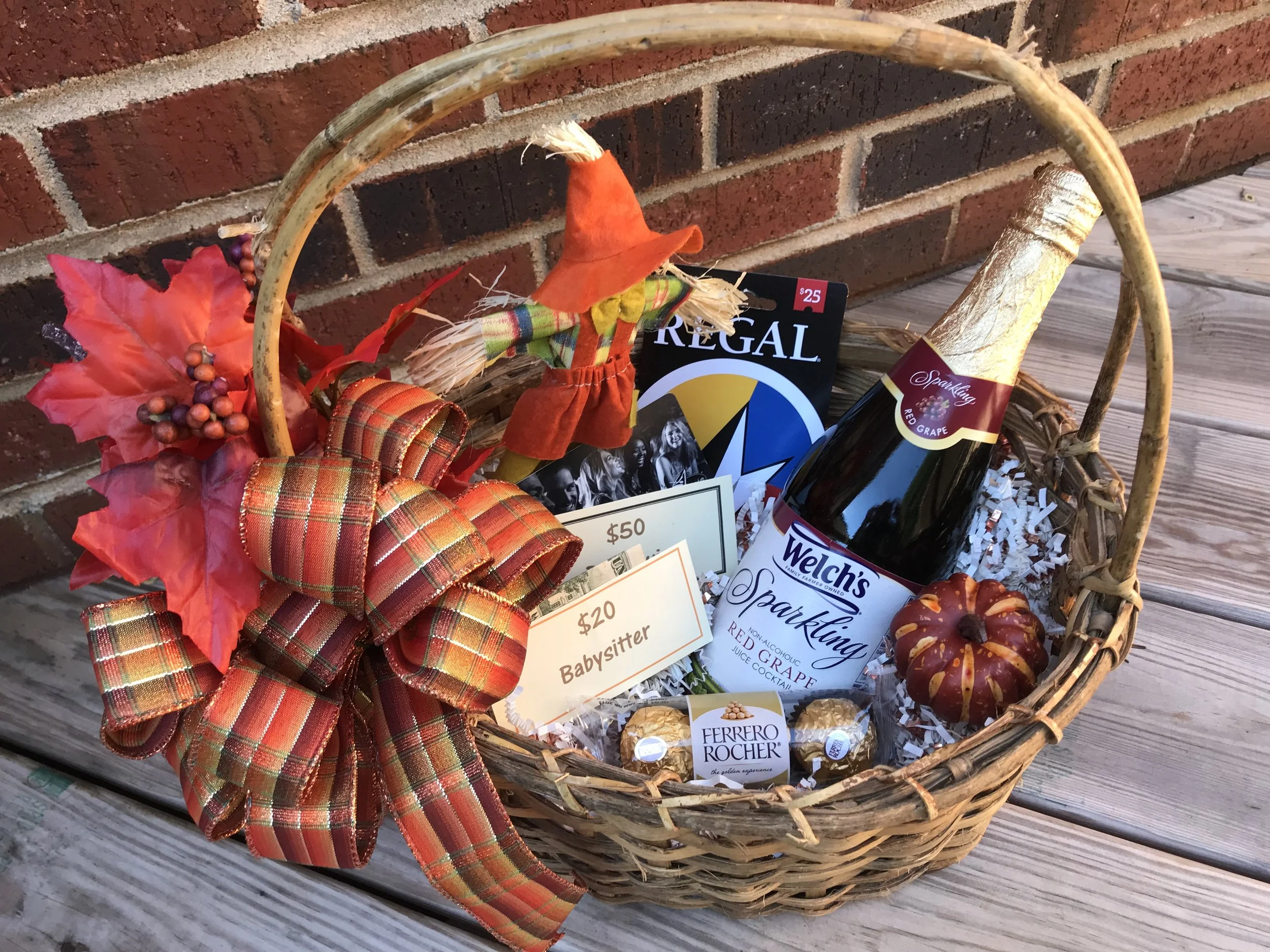 PARENTS’ MOVIE NIGHT OUT No expense left unnoticed in this Parents' Night Out basket! Enjoy $50 for dinner or drinks at Bar Louie, $25 for a movie at Regal, $20 towards a babysitter, and a bottle of Sparkling Red Grape Juice (non-alcoholic) to enjoy with Ferrero-Rocher Chocolates for dessert. DONOR: 5th Grade Classes VALUE: $100