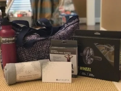 “I WORKOUT” AT HOME BAG Stay fit and looking great without ever leaving your house! Included are $50 Athleta gift card, water bottle, yoga towel, fitness mini bands, and an ab wheel all inside this awesome Reebok gym bag. DONOR: 3rd Grade Classes VALUE: $110