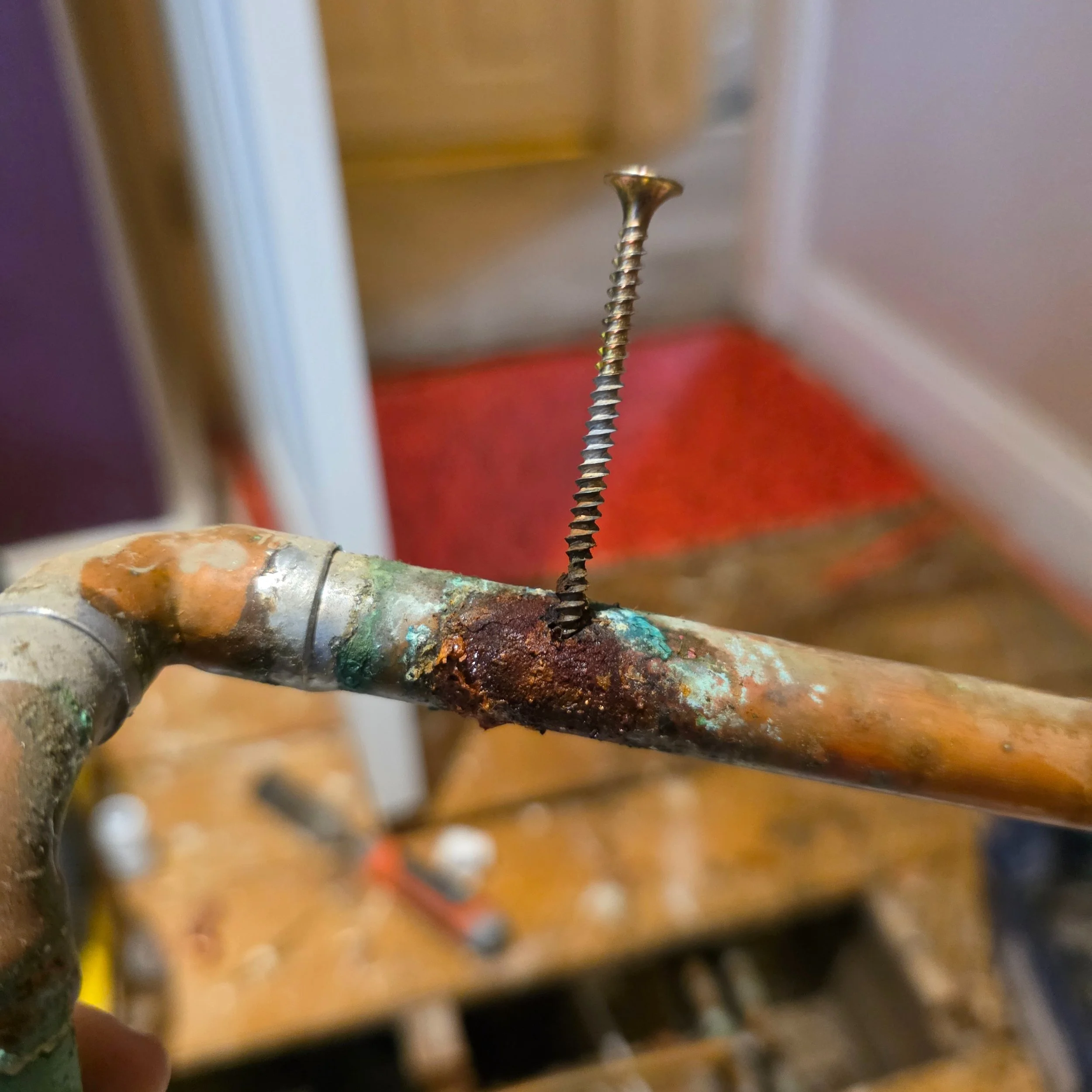 Bullseye! 🎯

We found this leaking heating pipe that had been screwed through when the carpet fitters were securing creaky floorboards. It had been like this for 3 years!

We removed the section and repaired.

Be careful out there!

We will beat any