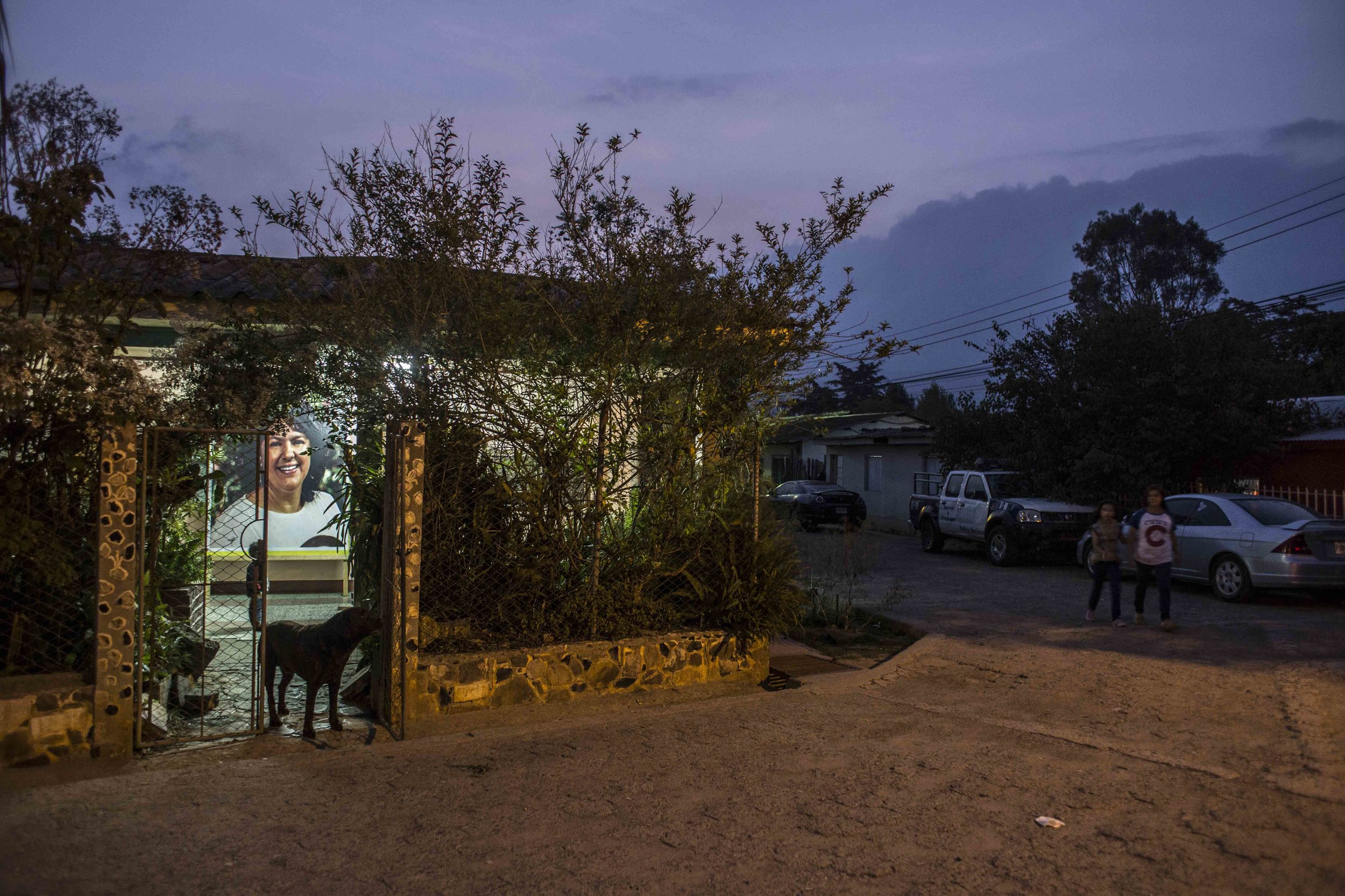 A big photo of Berta Caceres, seen from the street, place inside the family home in his memory, in the city of La Esperanza, Honduras. The house of his assassination is constantly guarded by a police patrol.