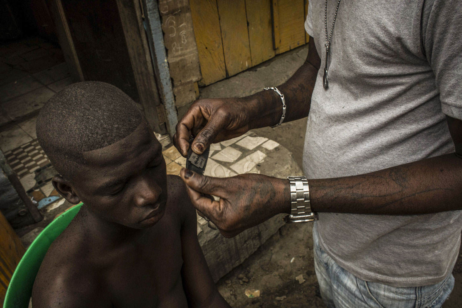 Barber on the streets of Kinshasa, Democratic Republic of Congo. July, 2016. 