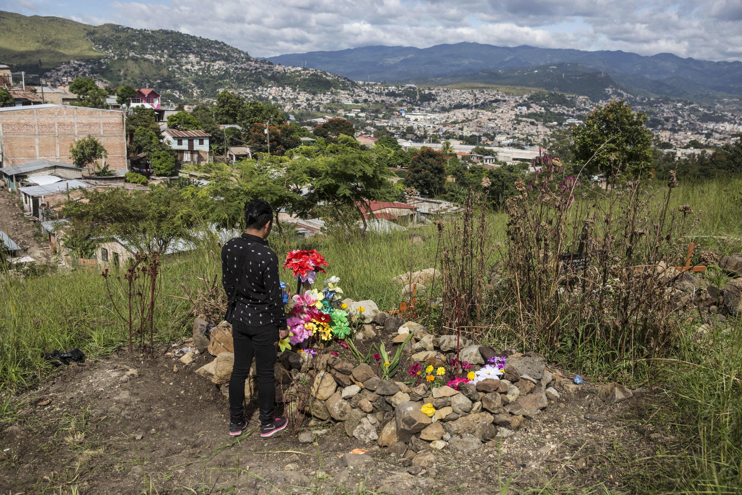  Darwin at his brother's grave overlooking Tegucigalpa, the capital of Honduras. Darwin is not safe, he has been threaten by the same gang that murdered his brother. In 2017, there have been 34 murders of LGBT community members in Honduras, according