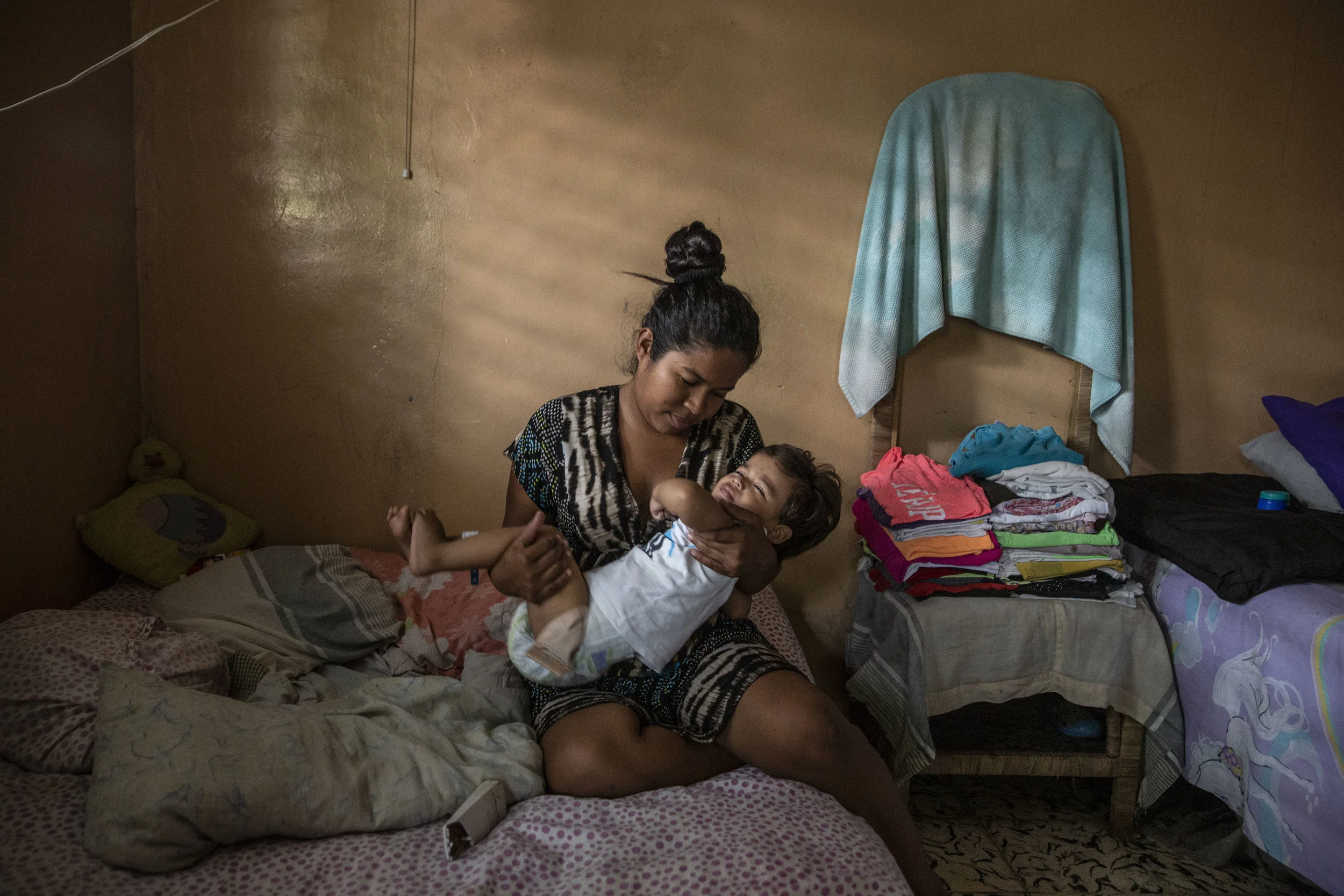 Claudia in her home holds his one year old child, Ricardo Lopez who just returned home from a nine hour long surgery at the Ruth Paz hospital in San Pedro Sula,, conducted by Dr.Craniotti, chief surgeon and specialist in anorectal disfunctions.