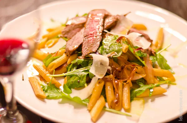 Biftecks aux oignons caramelisés, pâtes et roquette