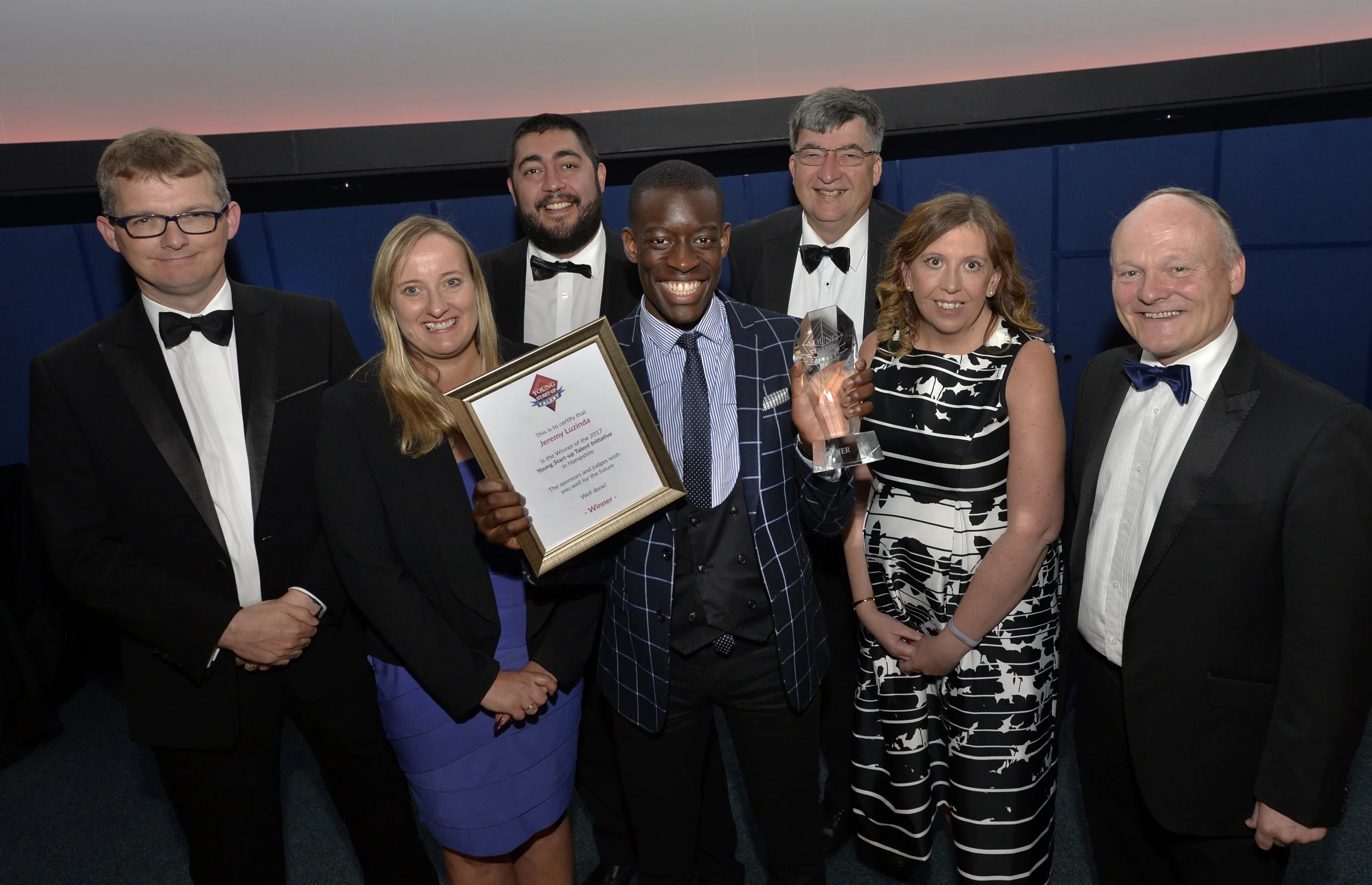 Judges with Jeremy Mutebi (centred) - left to right - Paul Stacey, Lorraine Nugent, Matt Turner, Chris Allington, Cheryl Gourlay and Royston Smith MP