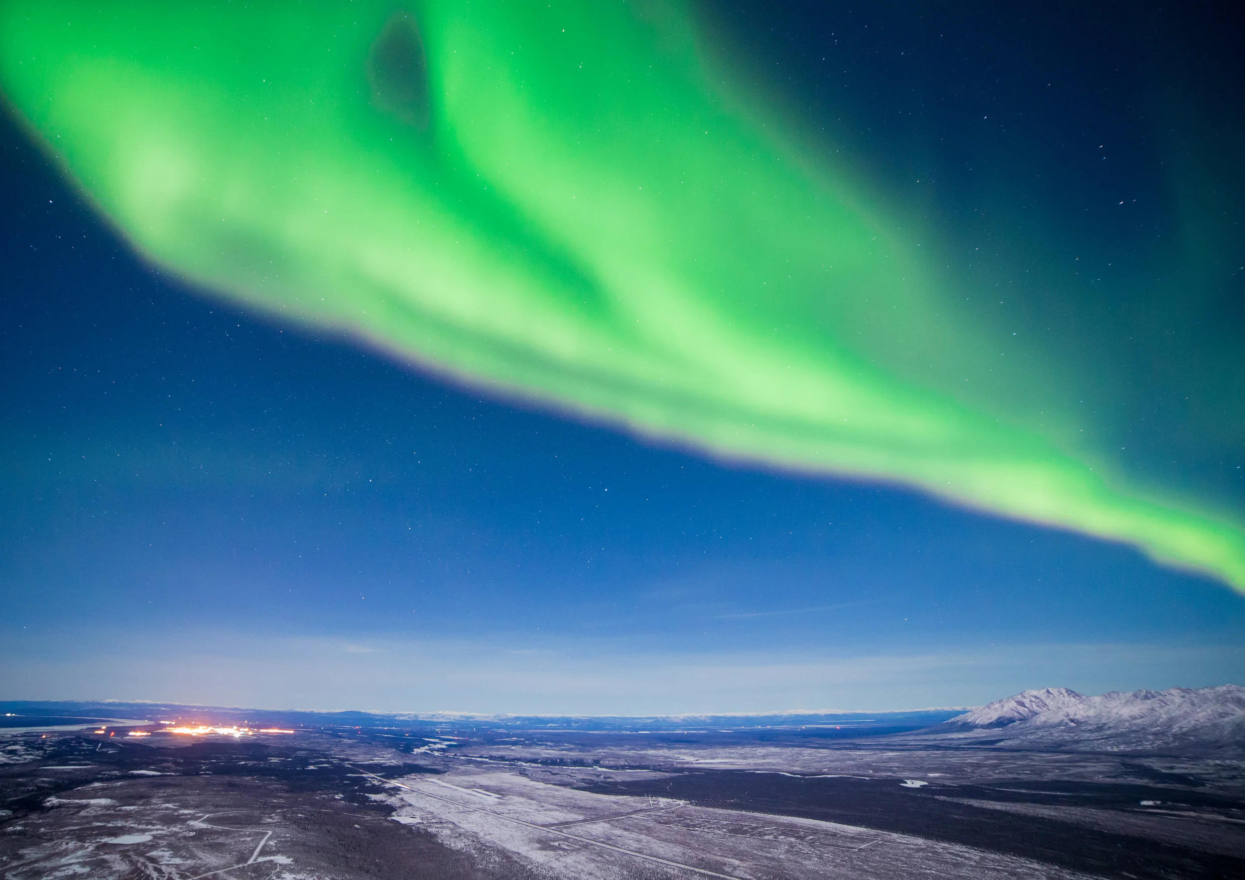 The aurora comes alive over the lights of Fort Greely and Delta Junction.