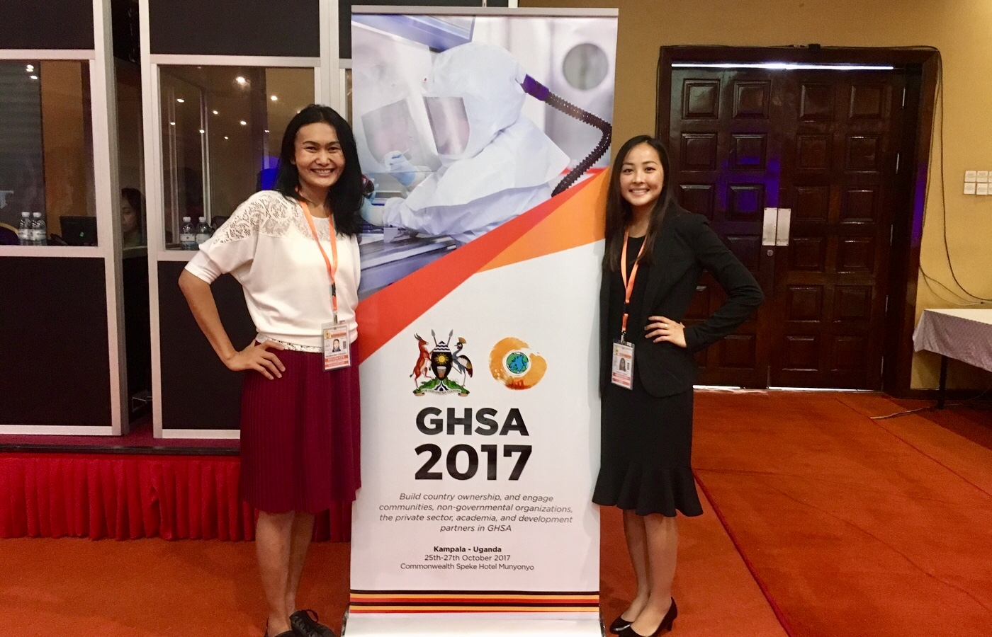 From left to right: Lyazzat Musralina (Institute of General Genetics and Cytology, Kazakhstan) and Ashley Tseng (McGill University, Canada) are shown here standing next to the Global Health Security Agenda 2017 Ministerial Meeting banner in Kampala, Uganda.