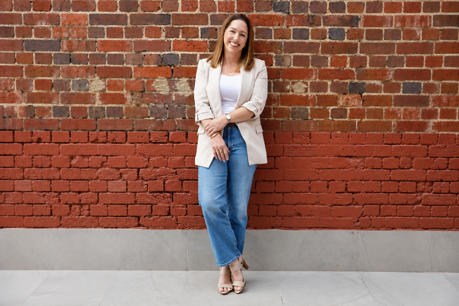 Smiling Woman Against Brick Wall.png