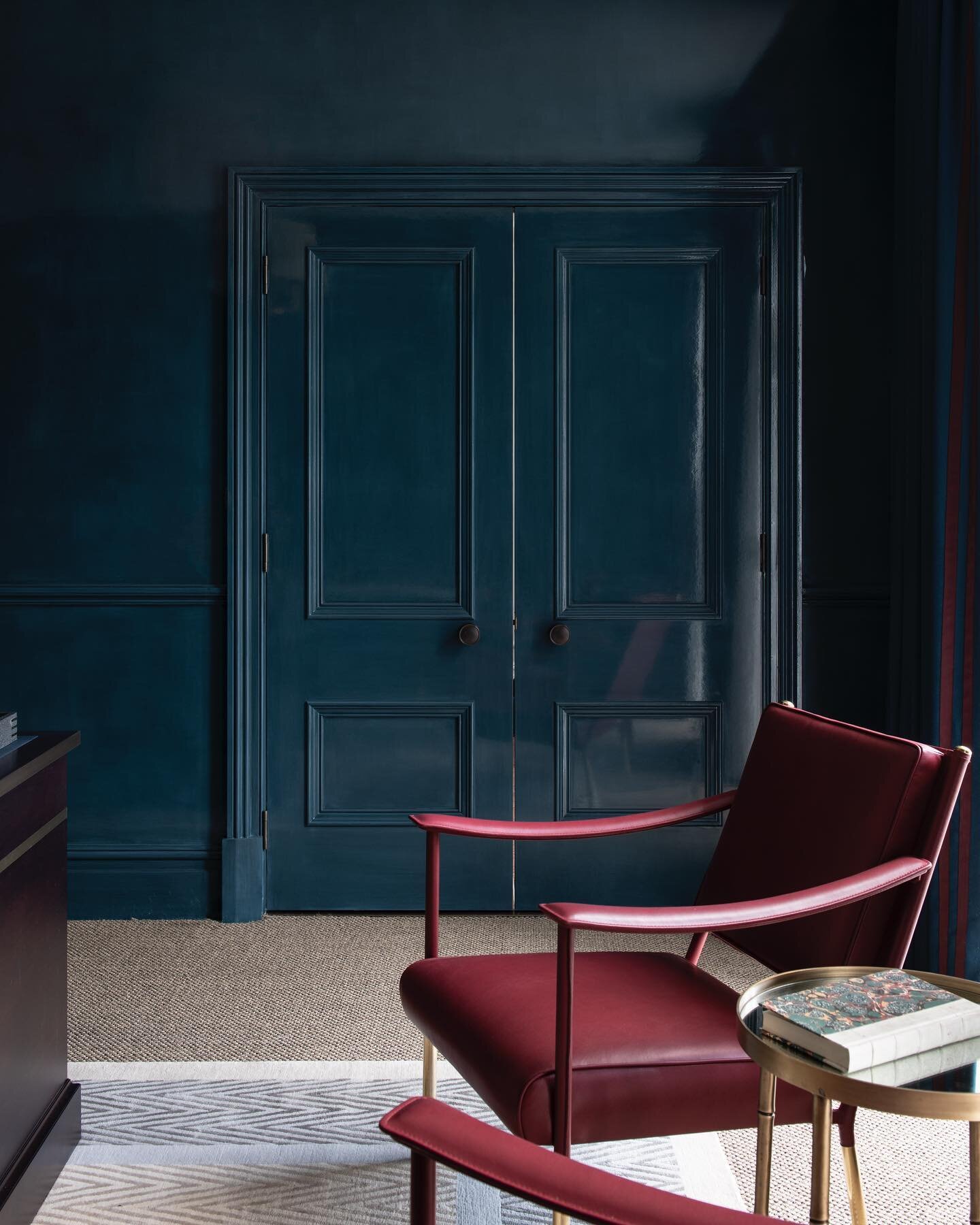 Decadently lacquered walls and woodwork contrast against a pared back textural sisal carpet in this home office. The process of applying this lacquer finish is intricate and takes hours upon hours of dedication from a specialist team, leaving a finis
