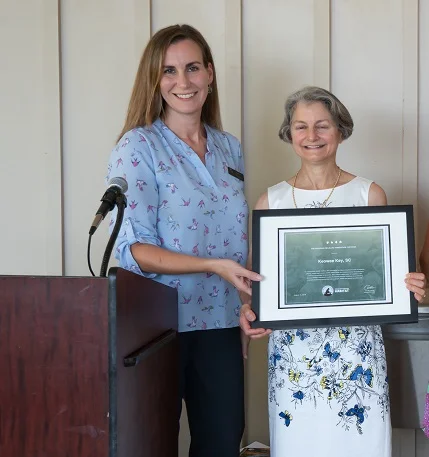 Sara Green, SCWF Director of Education, presents the certificate to Alice Guzick who spearheaded the application for the community.