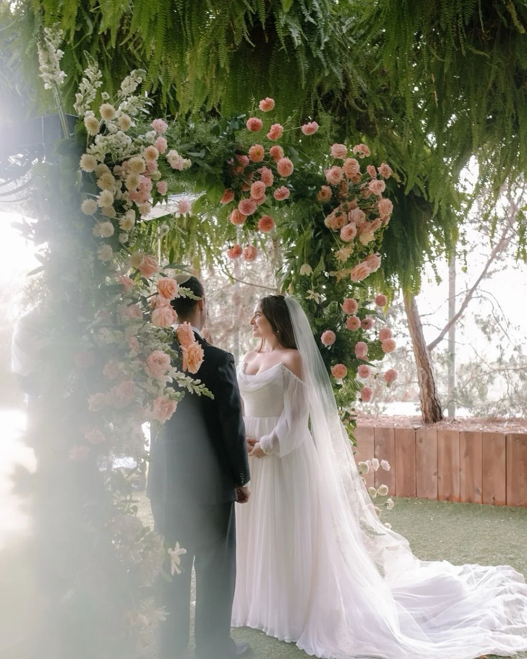 Tiana &amp; Dylan, beneath a canopy of lush green, with cloudy skies overhead and so much love around them. 
Tiana has the kind of beaming smile you can&rsquo;t help but return, and a thoughtfulness that makes others feel so important and cared for. 