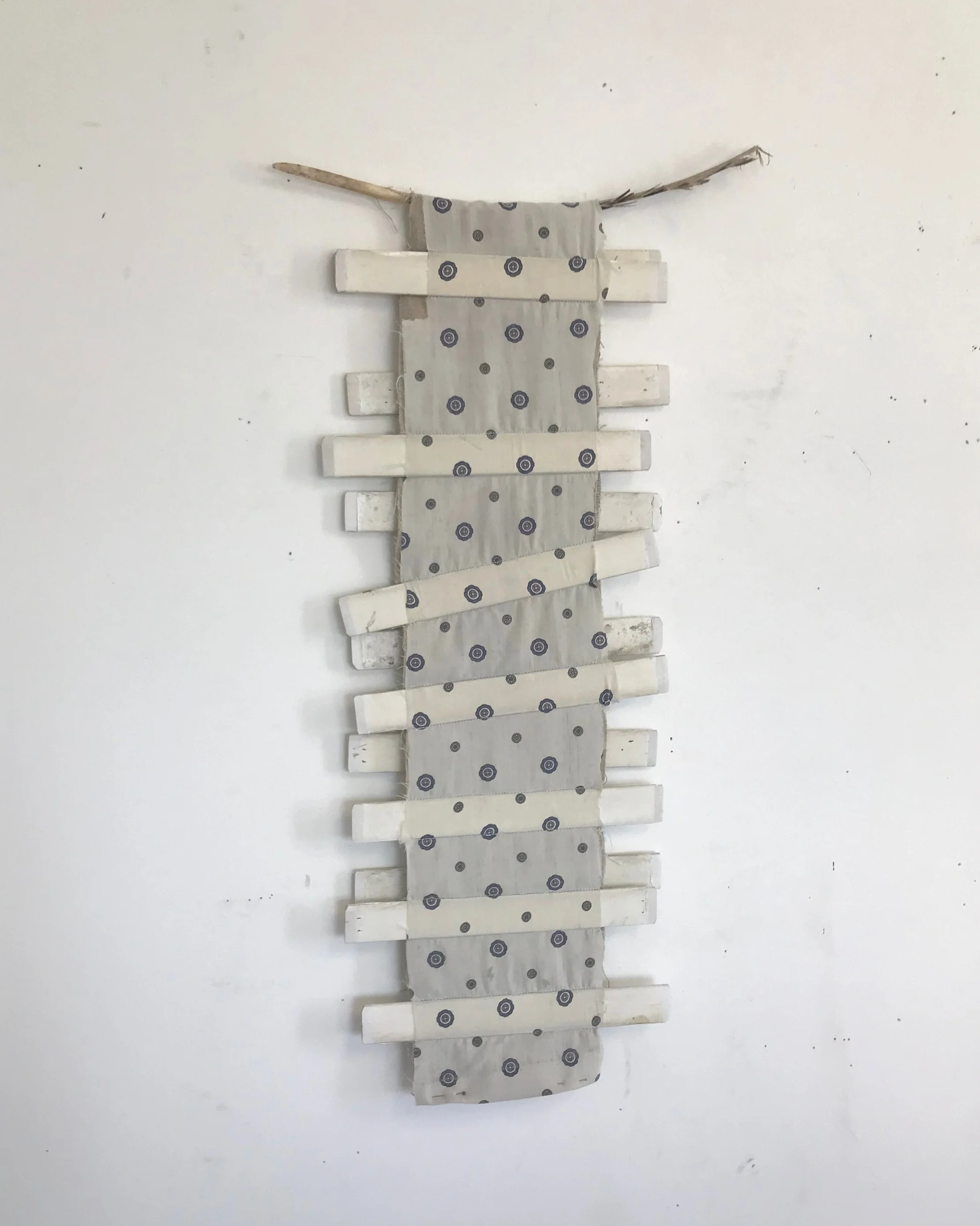 found wood sewn into linen and found fabric, feather, 2019