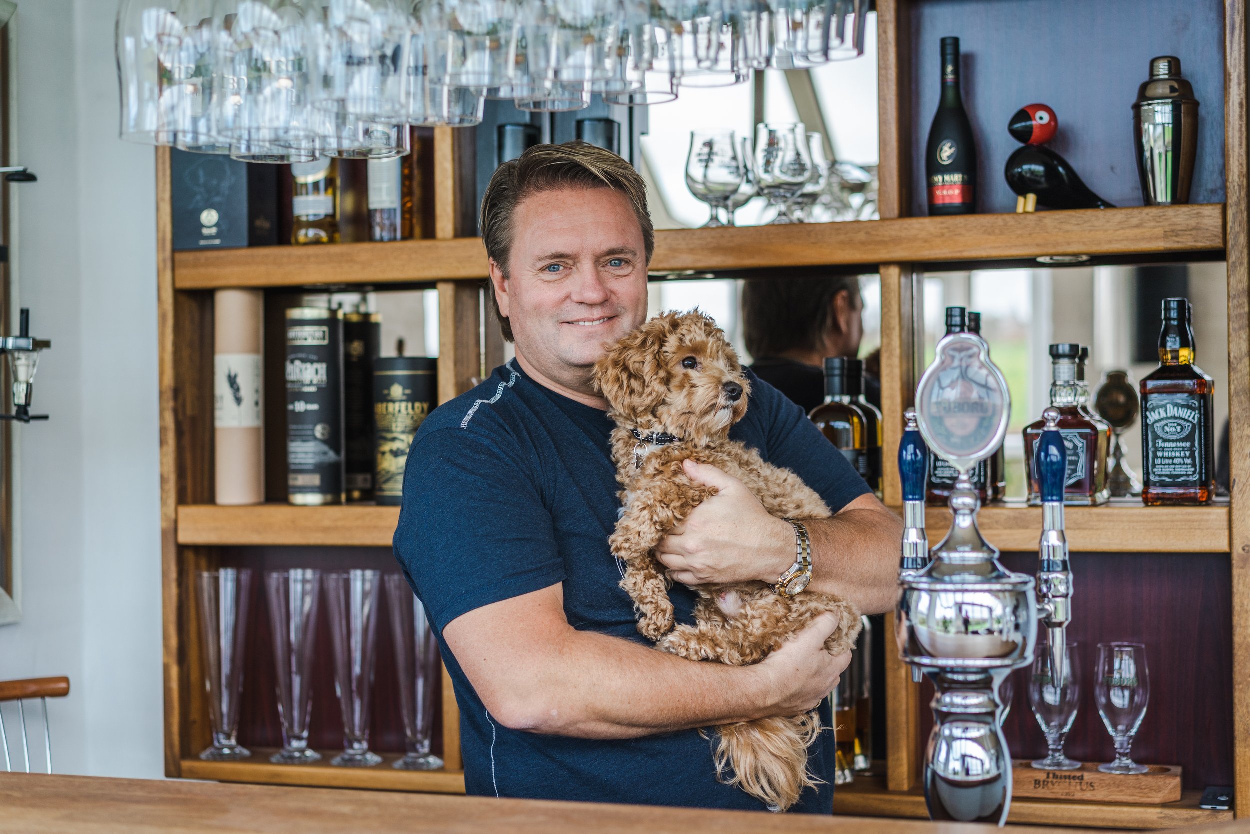 Johnny Hansen from Kandis in the house bar with his dog Bailey, assignment for LEV