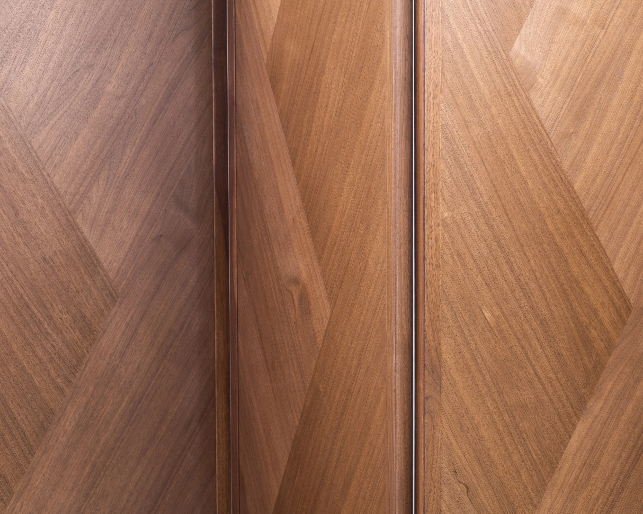 Detail of angular walnut veneer pattern on the screen panels.