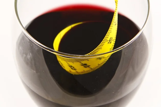 At The Lush Life, we believe that you can and should drink wine on a diet. Red wine glass with tape measure.