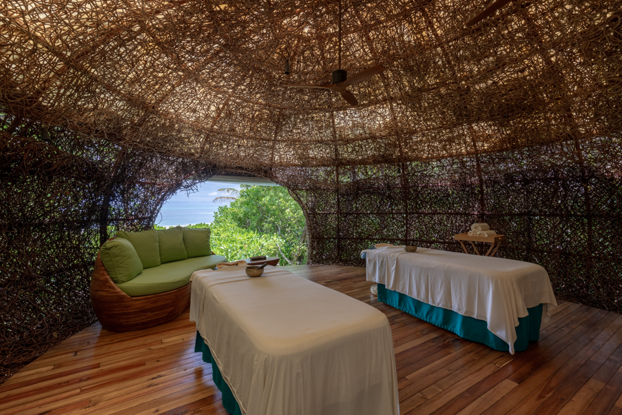 Inside a spa treatment room made of woven tree branches