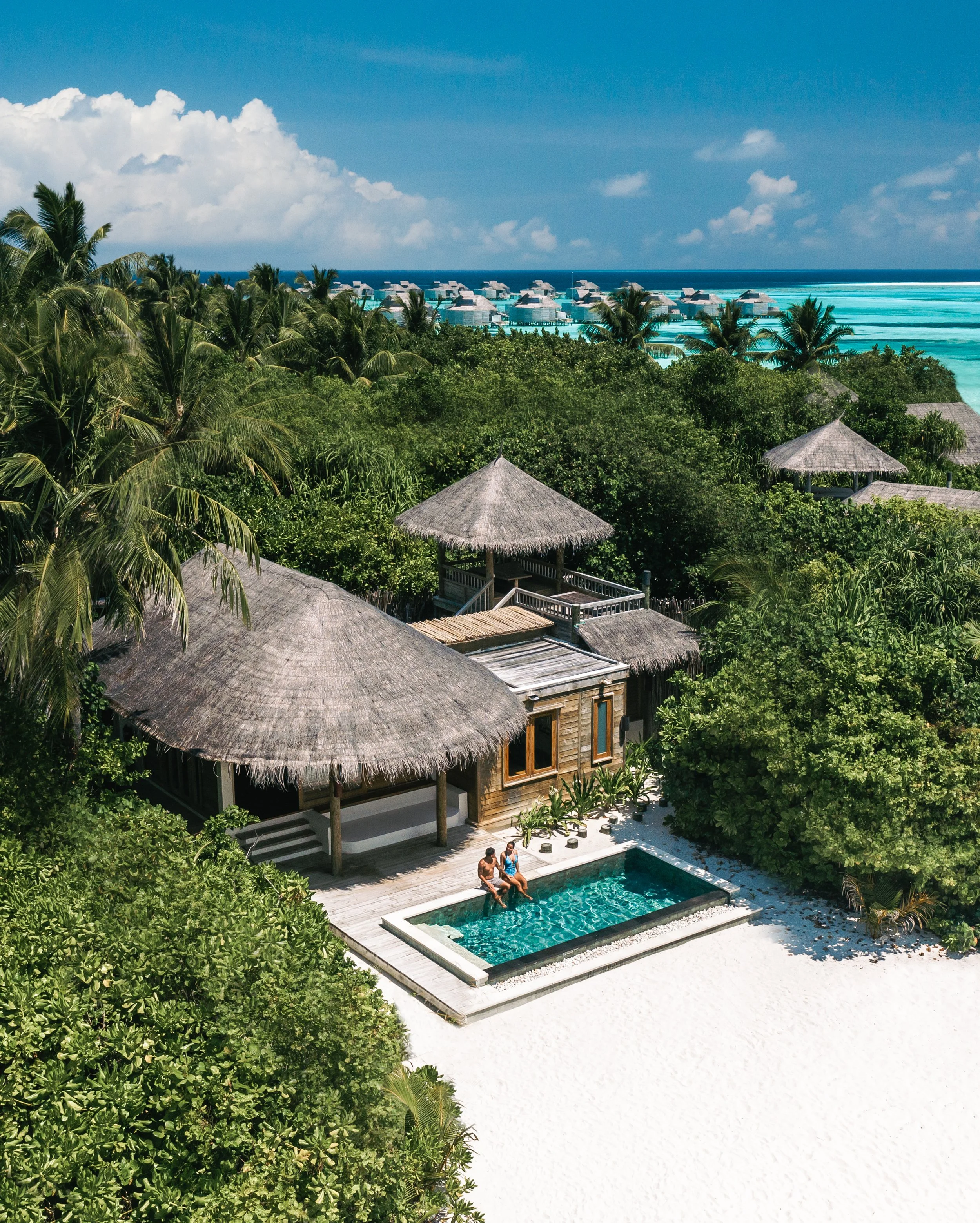 Beach Villa with people sitting in pool