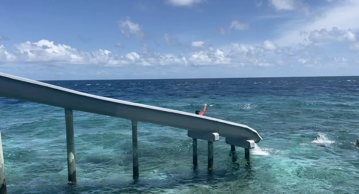 Child sliding down water slide into the lagoon