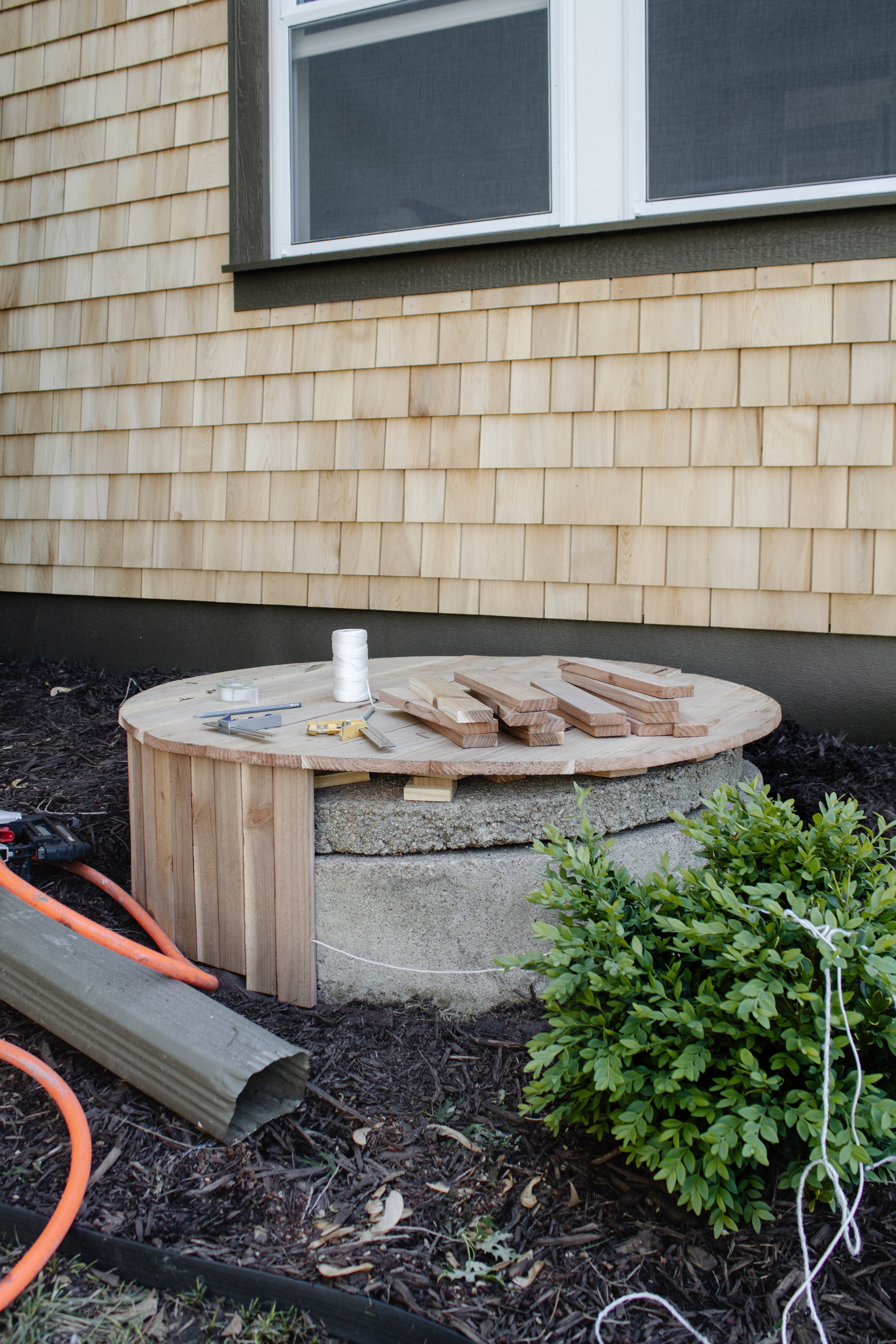 How we hid our well & a DIY well cover made of cedar fence boards. How to build a well cover with cedar wood. How to disguise a well in your yard or landscaping. Wood slat well cover by Nadine Stay