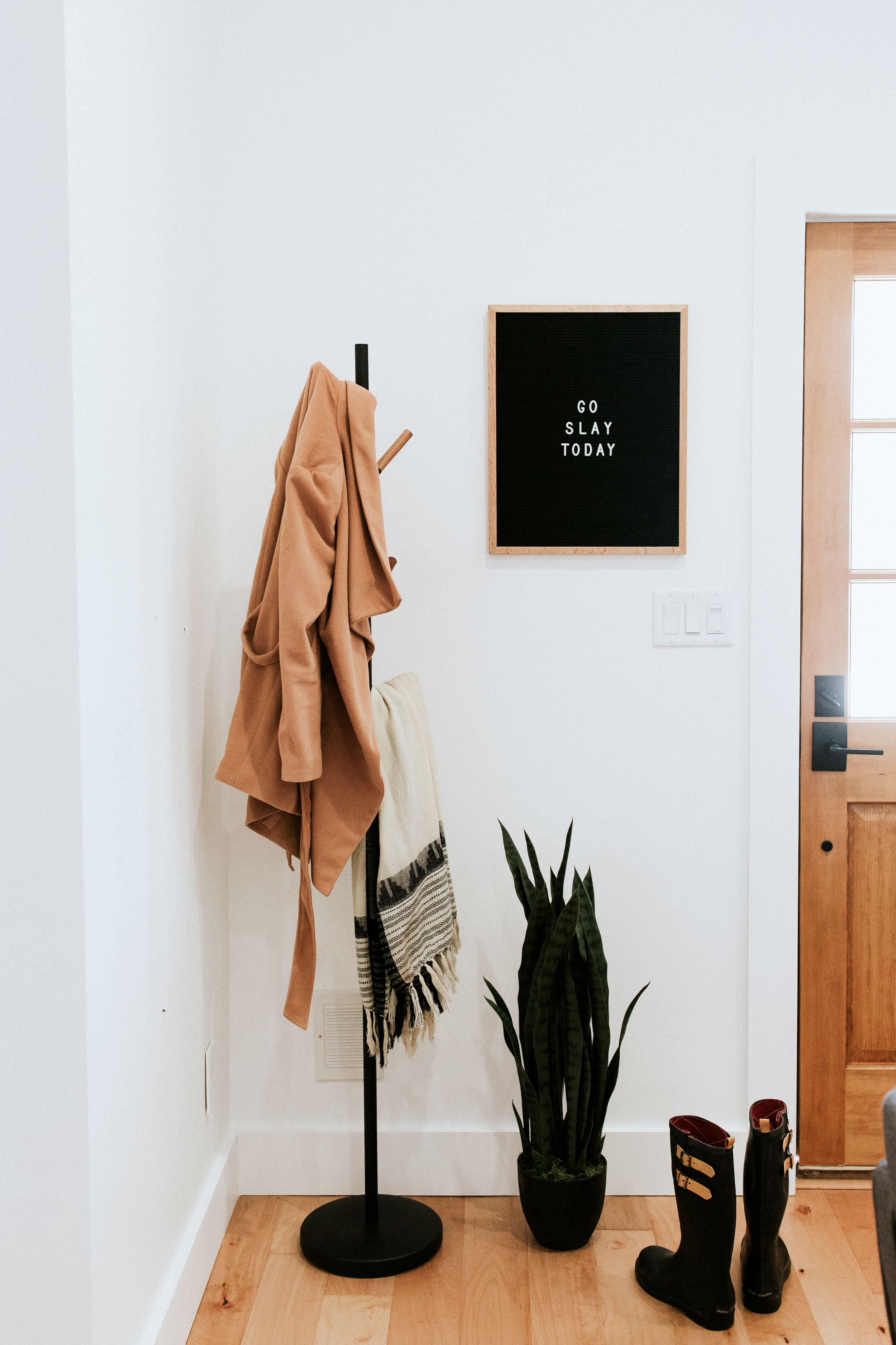 how we styled our entryway - modern minimal style inspiration featuring industrial coat rack, letterboard, and snake plant