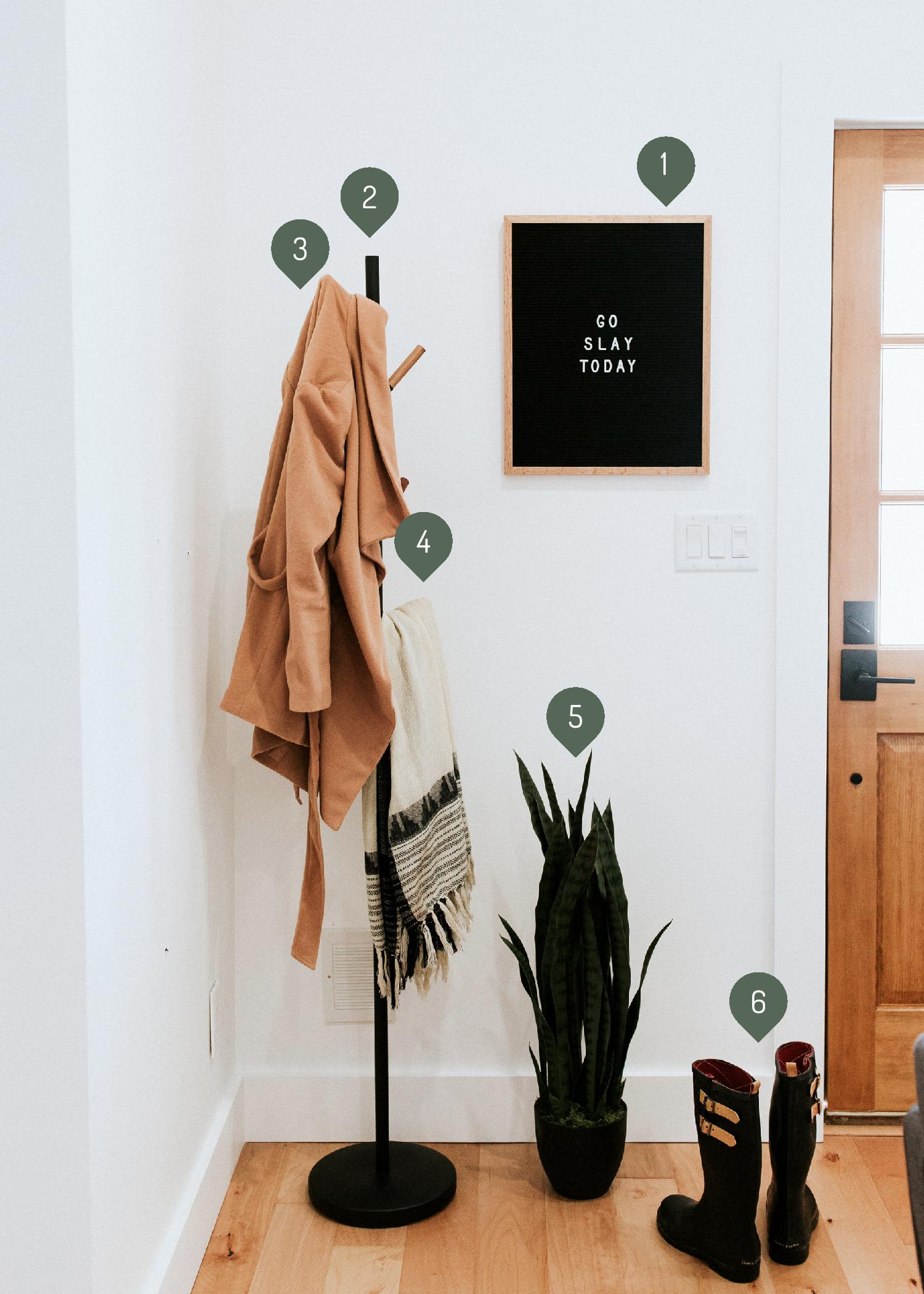 how we styled our entryway - modern minimal style inspiration featuring industrial coat rack, letterboard, rain boots, and snake plant sources