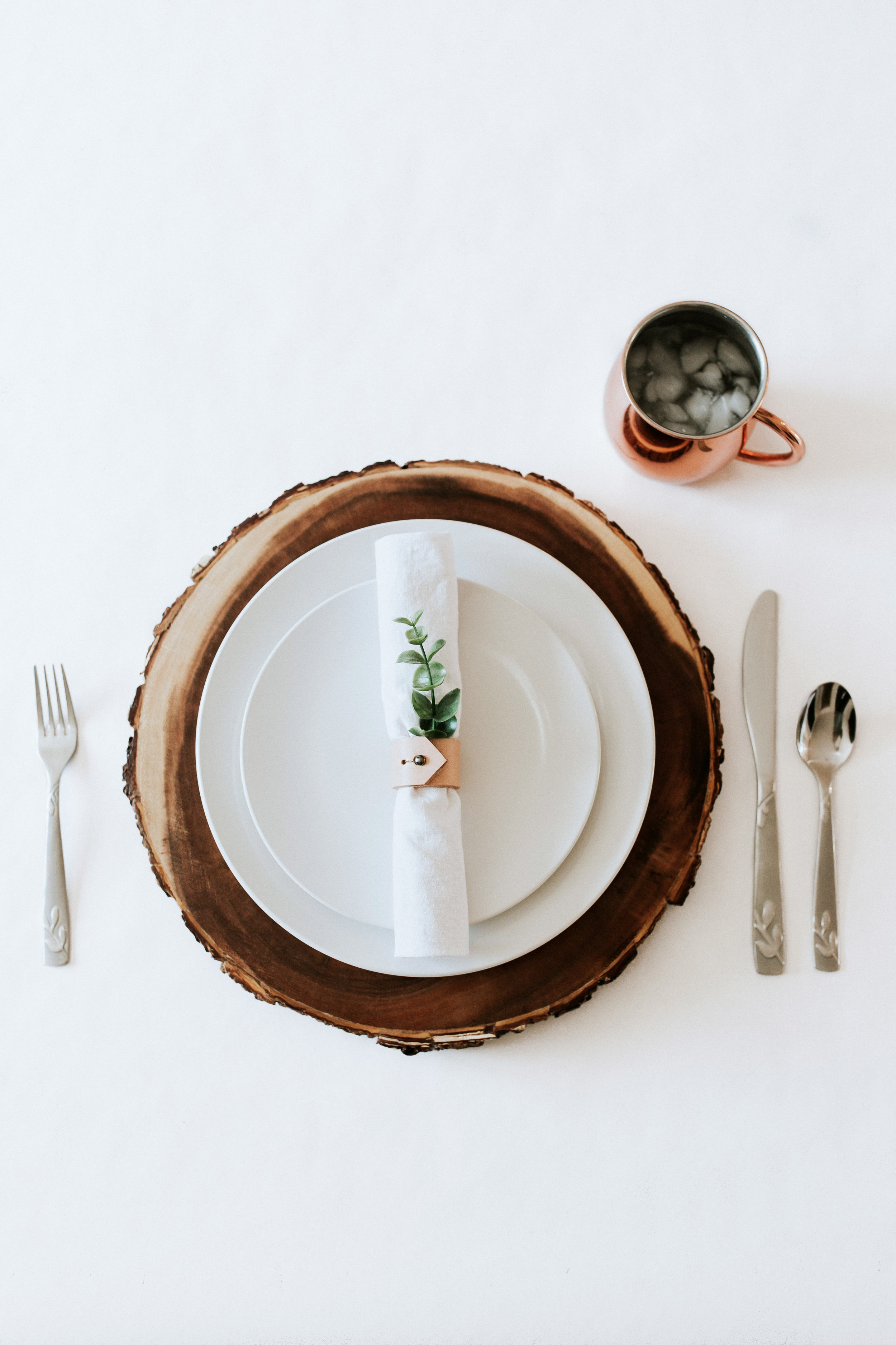 How to create / DIY a natural minimal table setting - wood charger, white plates, white napkin, leather napkin rings, greenery