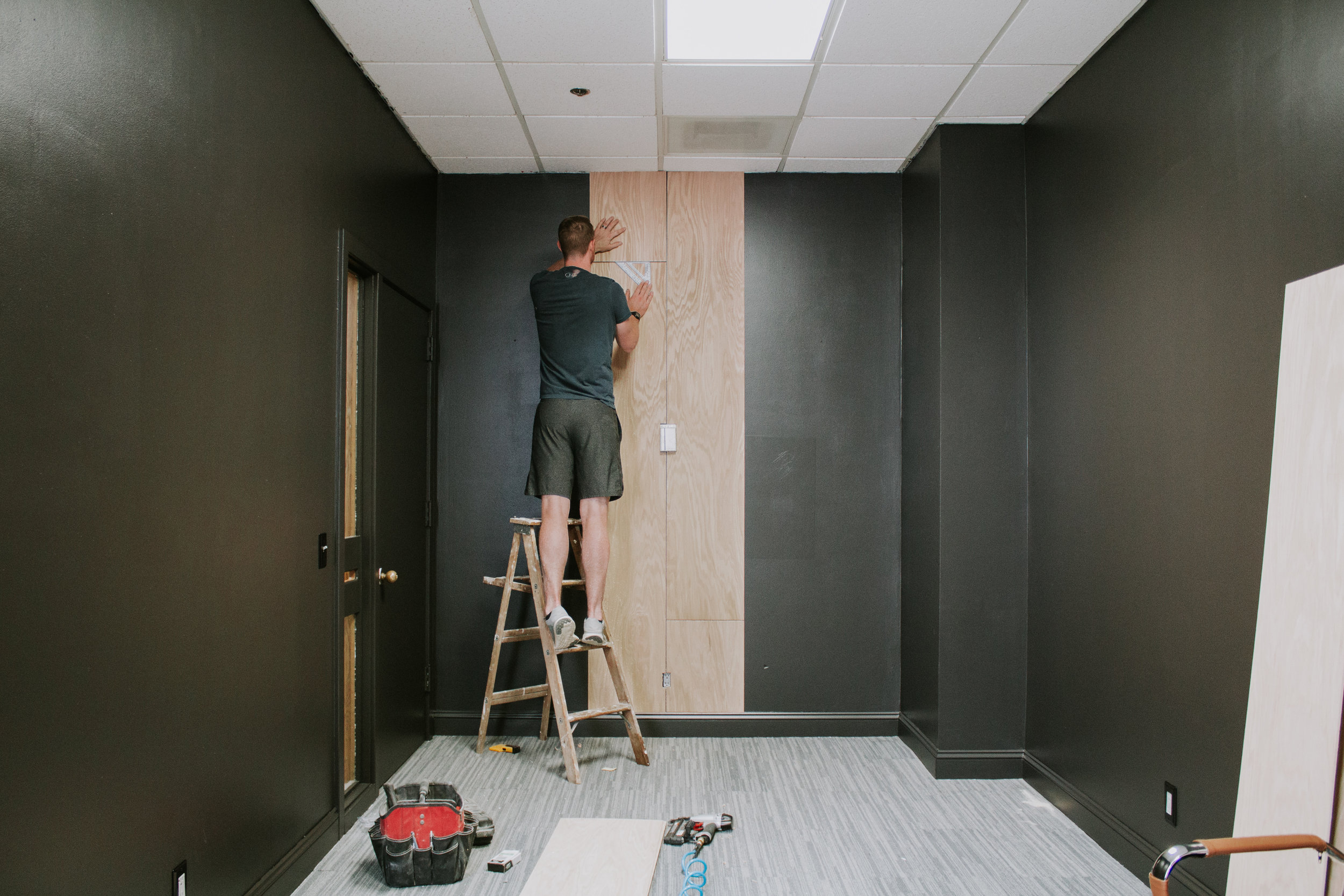 DIY Oak Plywood Accent Wall by Nadine Stay - turn a boring wall into a feature wall with vertical oak wood planking. Modern and retro style staggered accent wall with light oak wood. Speak Podcast Studio in Lincoln, Nebraska