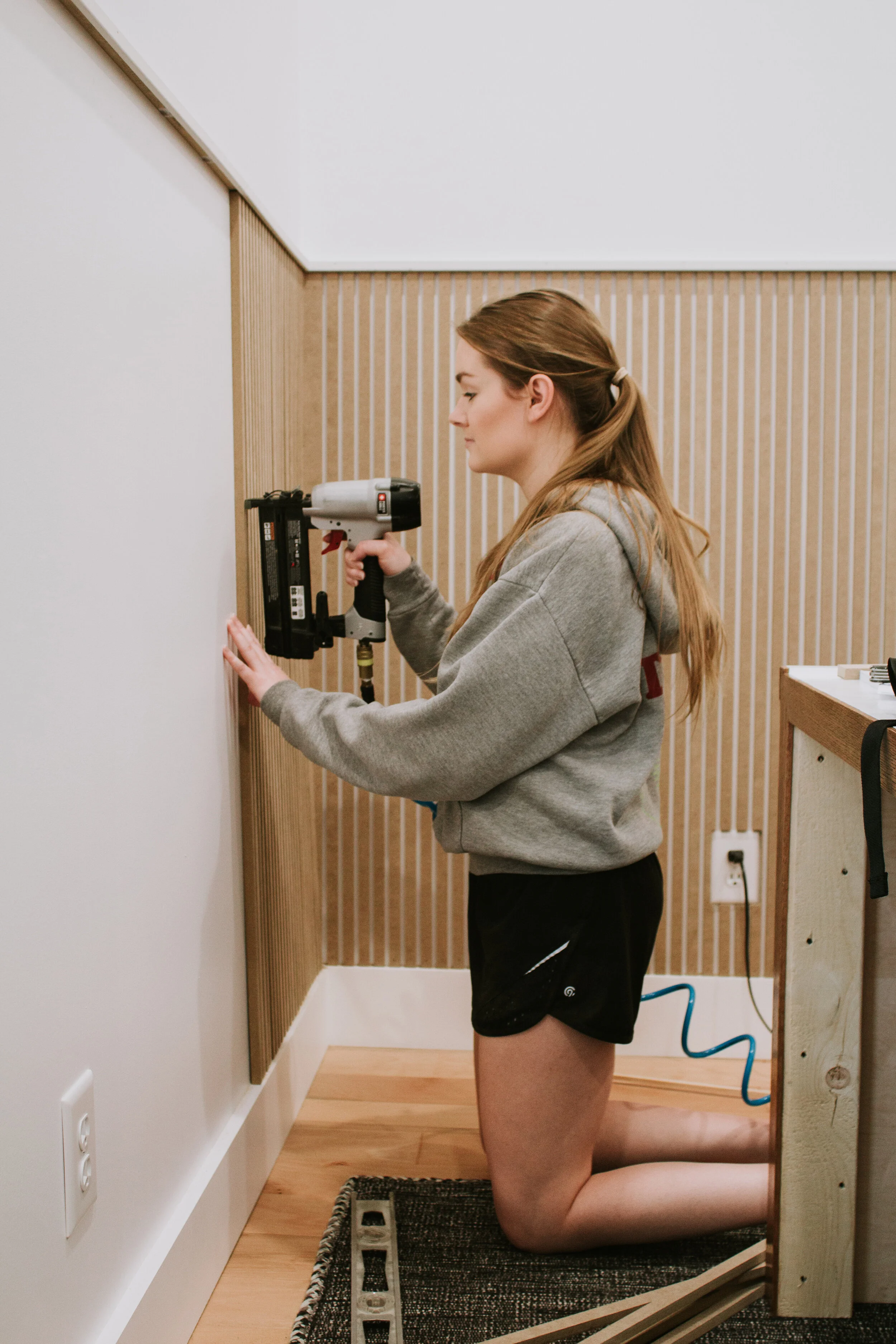 Installing modern wainscoting in our home office. Office makeover by Nadine Stay. Vertical slats painted in a rich hunter green. Full tutorial - how to install modern wainscoting in your home.