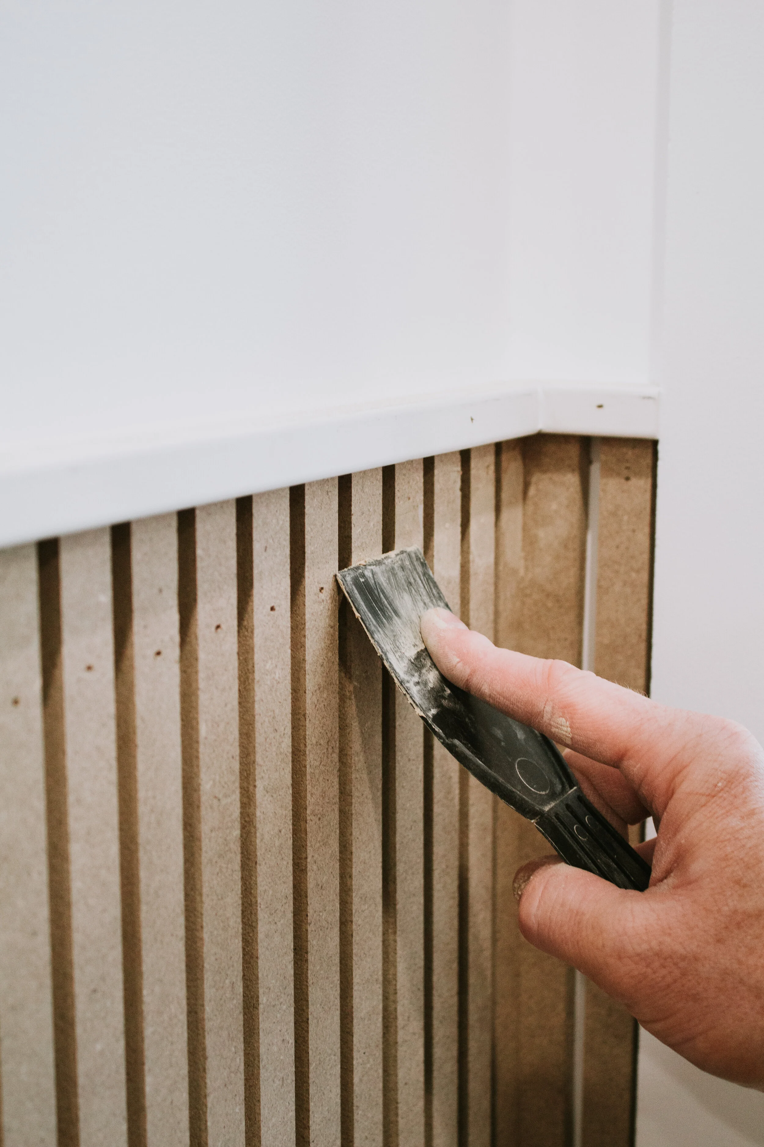 Installing modern wainscoting in our home office. Office makeover by Nadine Stay. Vertical slats painted in a rich hunter green. Full tutorial - how to install modern wainscoting in your home.