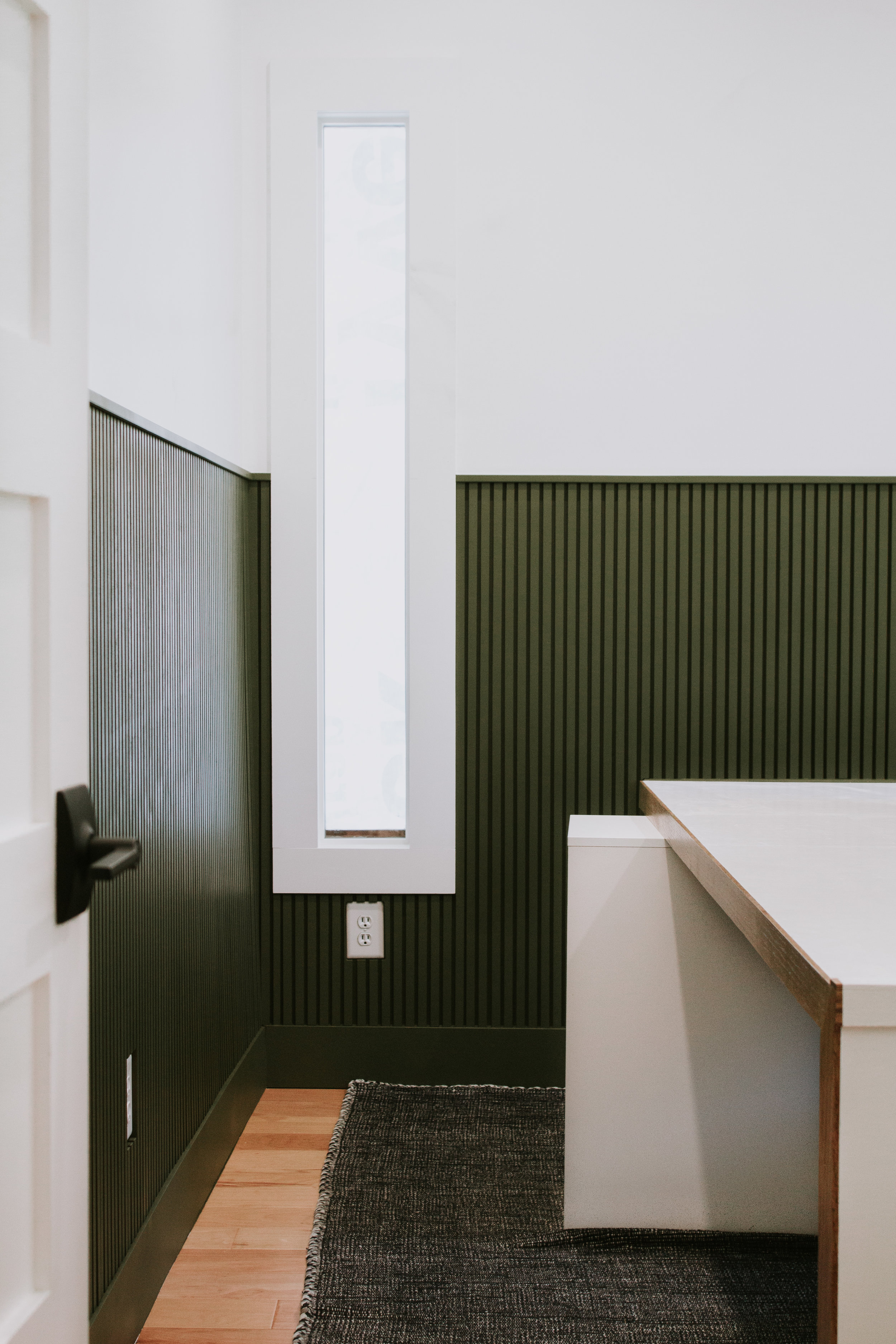 Installing modern wainscoting in our home office. Office makeover by Nadine Stay. Vertical slats painted in a rich hunter green. Full tutorial - how to install modern wainscoting in your home.