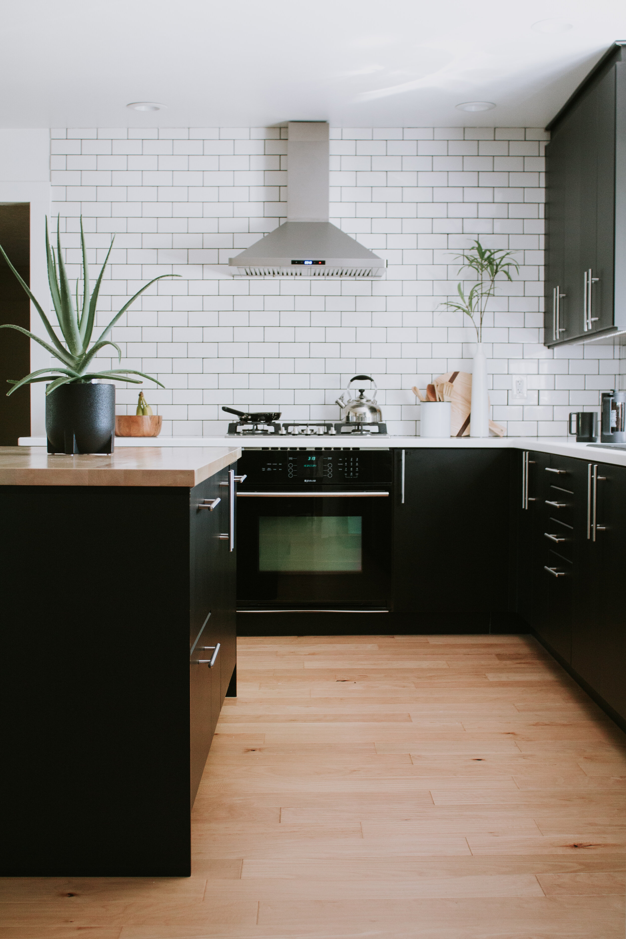10 home features we couldn't live without | Nadine Stay | Kitchen island with storage, built in microwave, transom windows above the interior doors, slide out trash can, dimmer switches, and a wood burning fireplace.