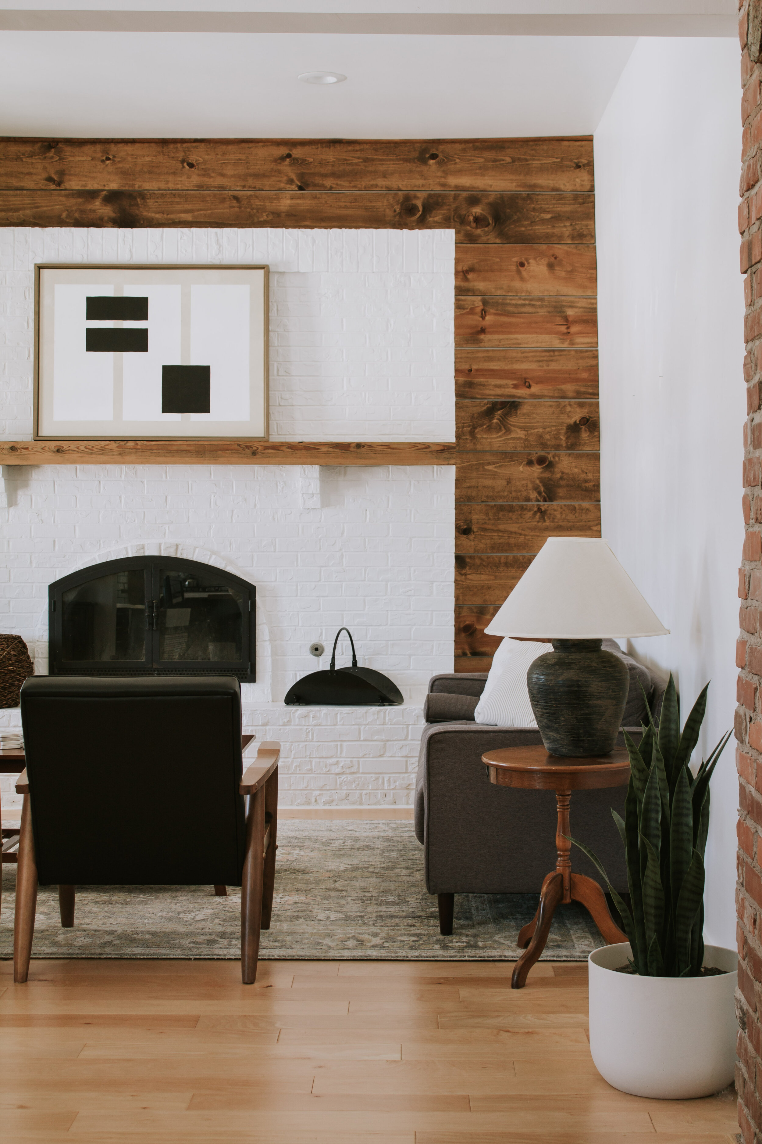 Our living room: what's working, what's not, and a makeover game plan - Nadine Stay | Modern cabin living room. Brick fireplace feature wall inspiration. Shiplap wood wall and living room design by Nadine Stay
